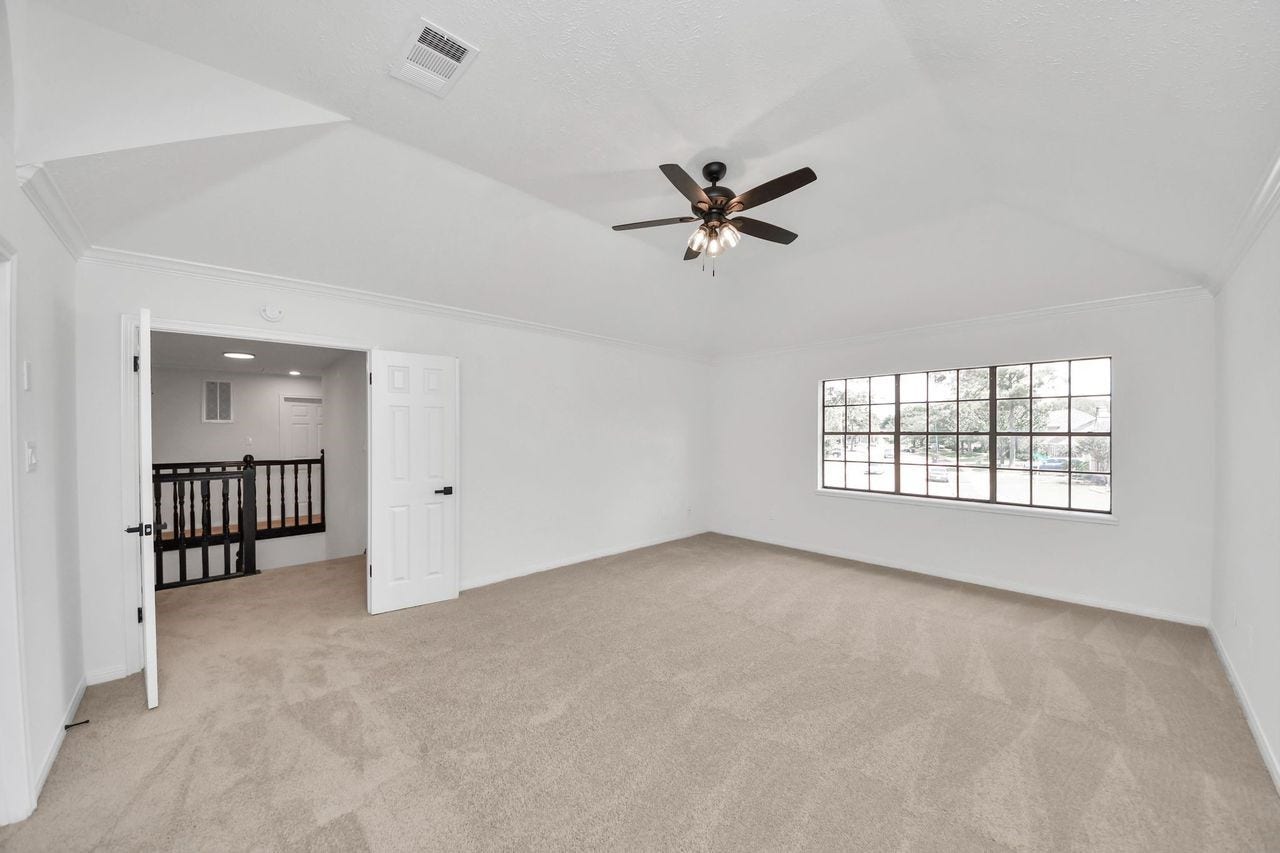 15047 Tramore Drive, Houston, TX 77083 With its expansive layout and abundant natural light, the upstairs primary bedroom offers a comfortable and versatile retreat. The large window, plush carpeting, and neutral finishes create a blank canvas ready to reflect your personal style.