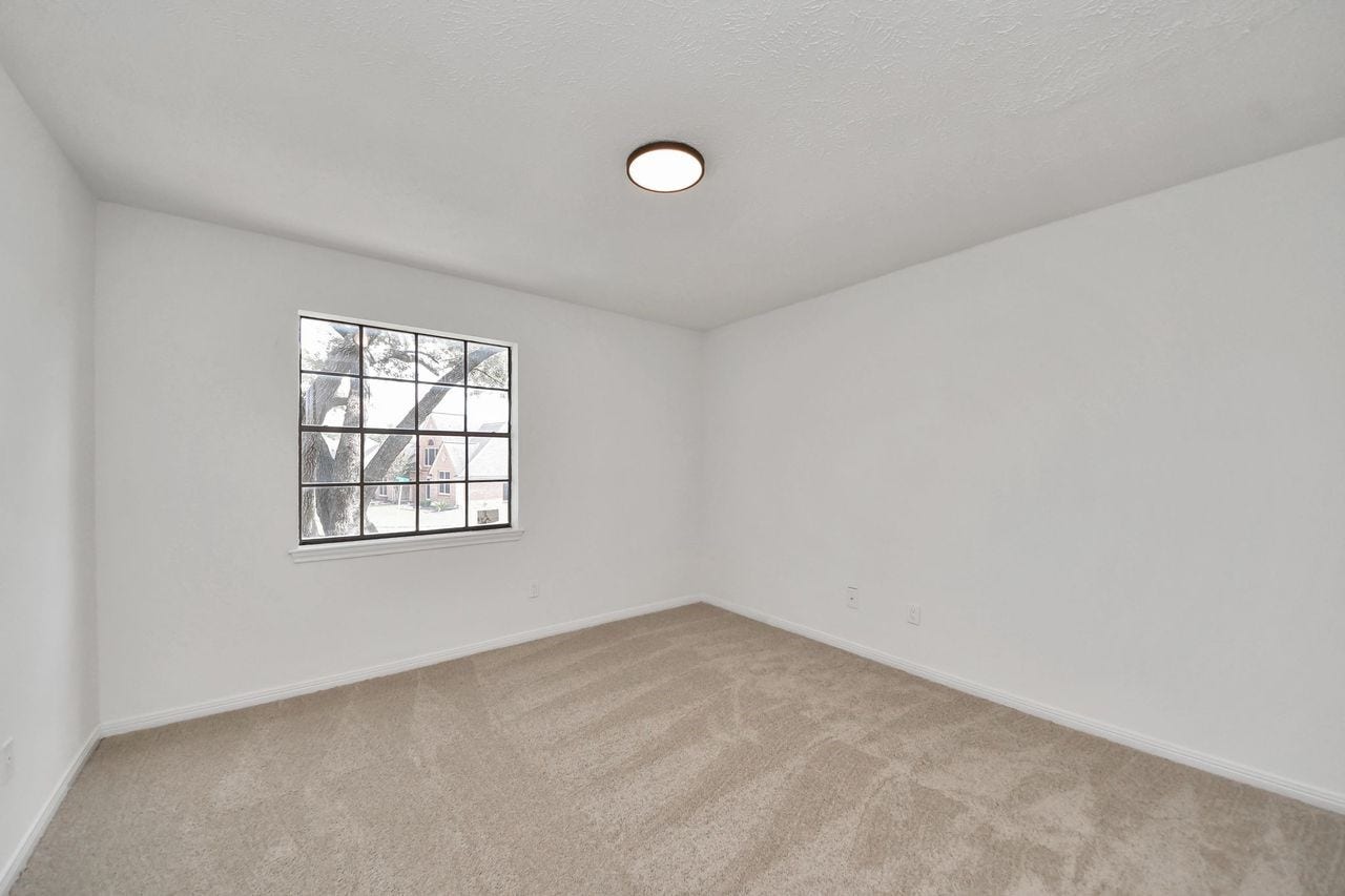 15047 Tramore Drive, Houston, TX 77083 All three spacious secondary bedrooms upstairs offer plush carpeting, a large window for natural light, and plenty of room for a bedroom suite, desk, or additional furnishings.