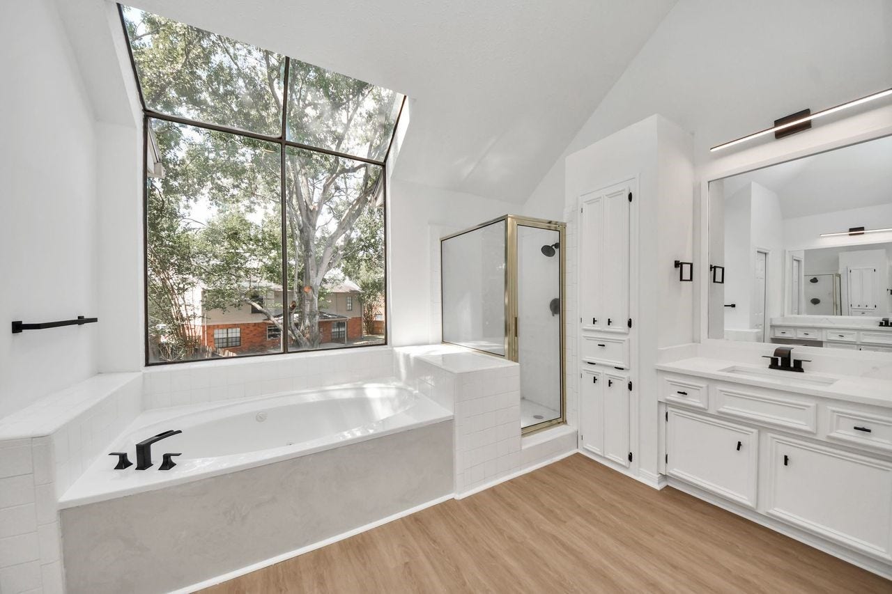 15047 Tramore Drive, Houston, TX 77083 A dramatic window fills the room with natural light and brings the outdoors into this relaxing retreat.