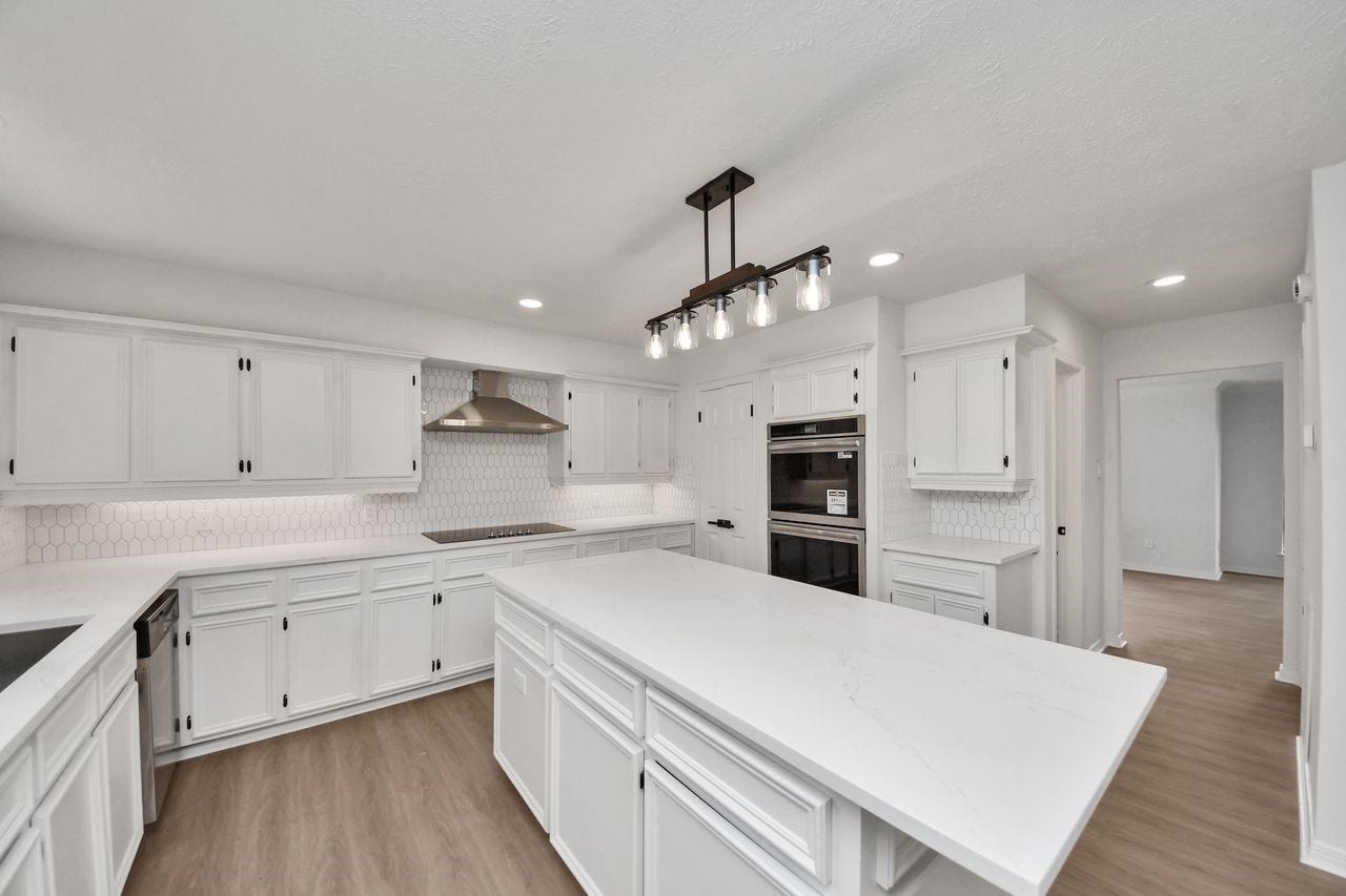 15047 Tramore Drive, Houston, TX 77083 Designed with both cooking and entertaining in mind, the kitchen offers generous counter space, extensive cabinetry, an oversized island, a custom light fixture along with recessed lighting and a sleek electric cooktop beneath a stainless steel vent hood.