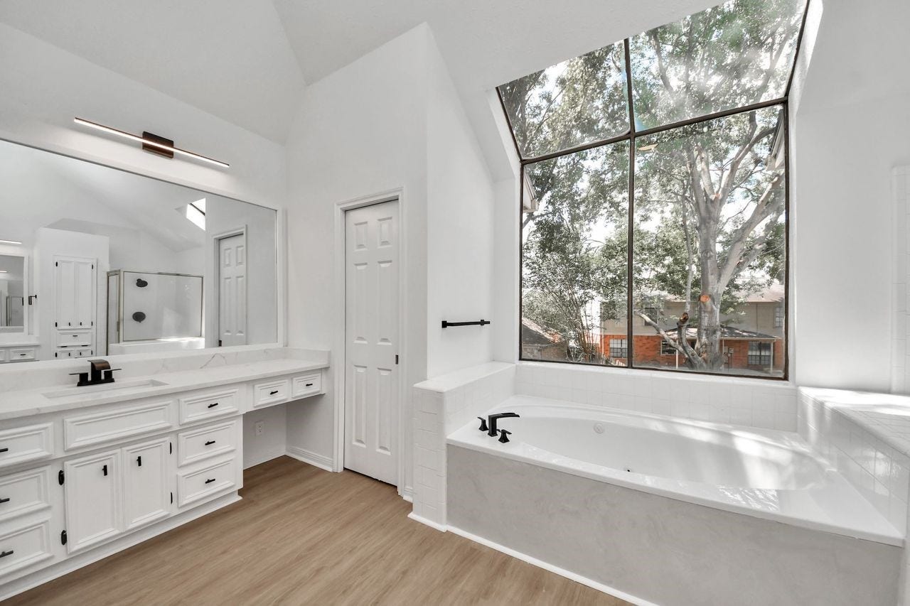 15047 Tramore Drive, Houston, TX 77083 The abundance of natural light highlights the crisp, white cabinetry, quartz countertops and custom fixtures.