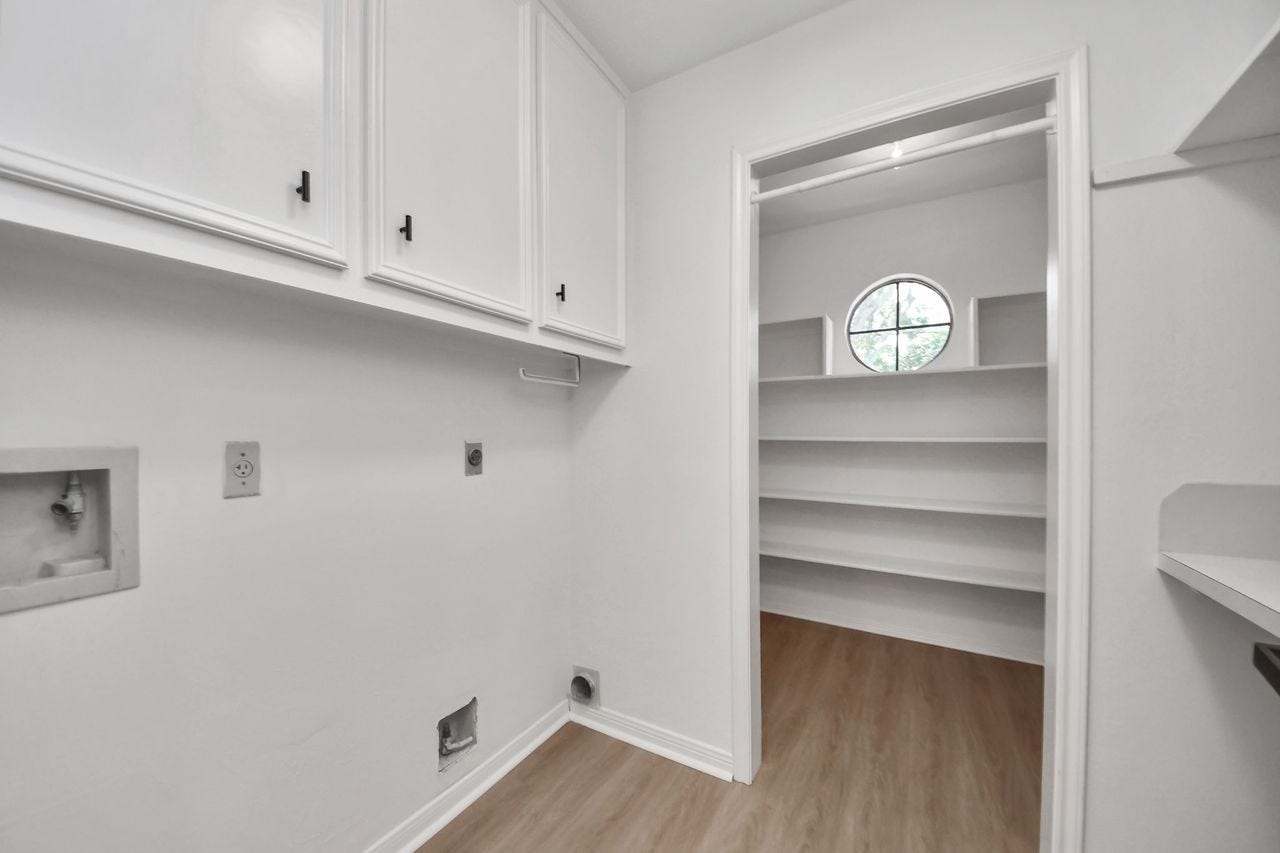 15047 Tramore Drive, Houston, TX 77083 The laundry room offers excellent functionality with built-in cabinetry, a dedicated utility sink area, and easy access to a spacious walk-in storage or pantry area.