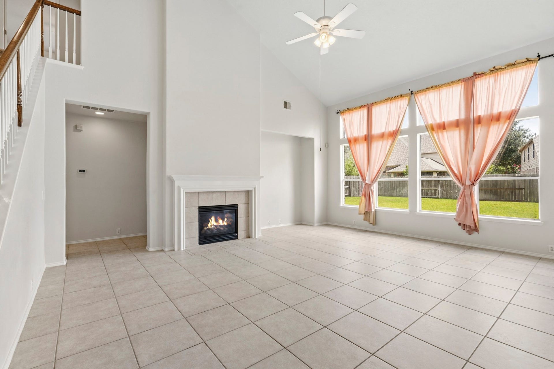 5515 Granite Meadow Drive, Katy, TX 77494 Expansive family room featuring a cozy fireplace, dedicated entertainment space, and views of the oversized, pool-sized backyard.