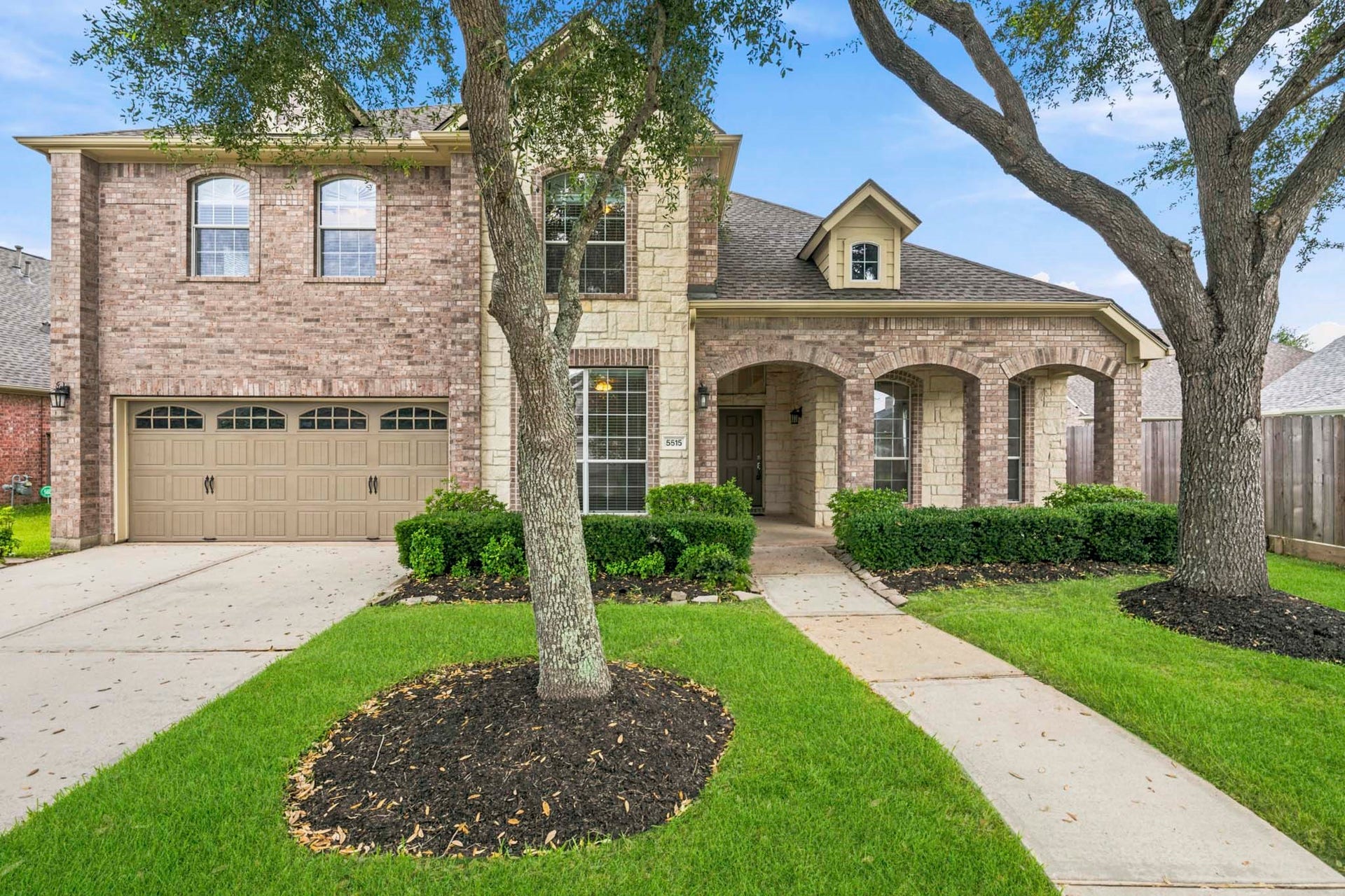 5515 Granite Meadow Drive, Katy, TX 77494 Welcoming front porch with comfortable seating area, framed by an attractive stone-and-brick exterior that creates outstanding curb appeal.