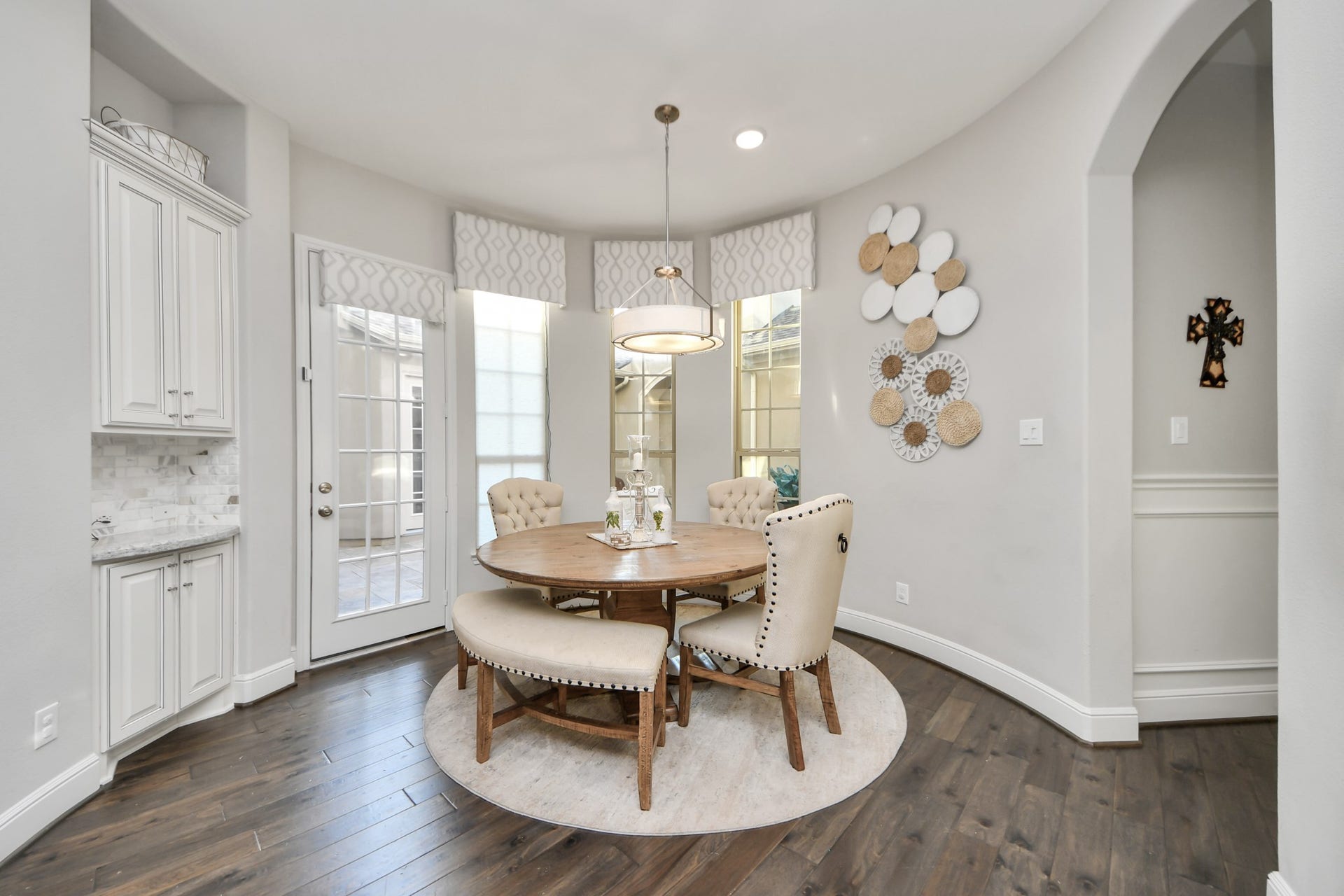 12821 N Palomino Lake Circle, Cypress, TX 77429 Inviting breakfast area featuring a convenient coffee bar, remote-controlled window coverings, and direct courtyard access. Adjacent hallway leads to the mudroom, utility room, rear staircase, and garages.