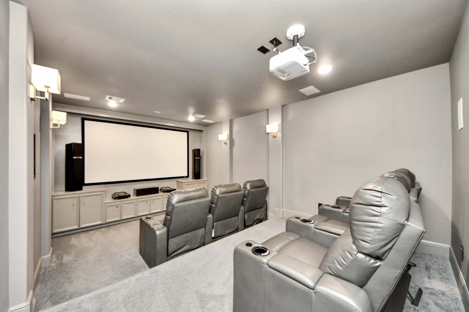 12821 N Palomino Lake Circle, Cypress, TX 77429 Another view of the private media room showcasing tiered theater seating, a large projection screen, dimmable lighting, and an immersive surround sound system. Premium audio/video equipment and reclining theater seating available with an acceptable full-price offer.