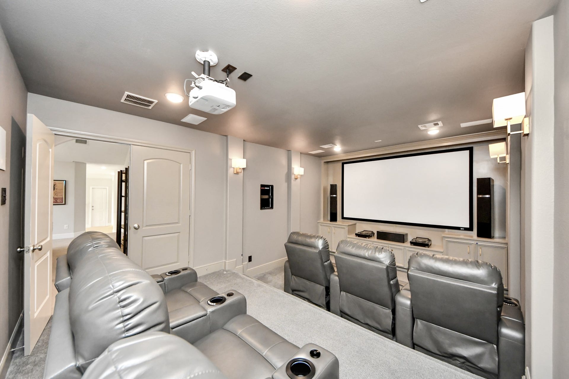 12821 N Palomino Lake Circle, Cypress, TX 77429 Private theater-style media room featuring tiered flooring for reclining theater seating, dimmable lighting, eight built-in surround sound speakers, and a premium projection system. Theater seating and select audio/video equipment available with a full-price offer.