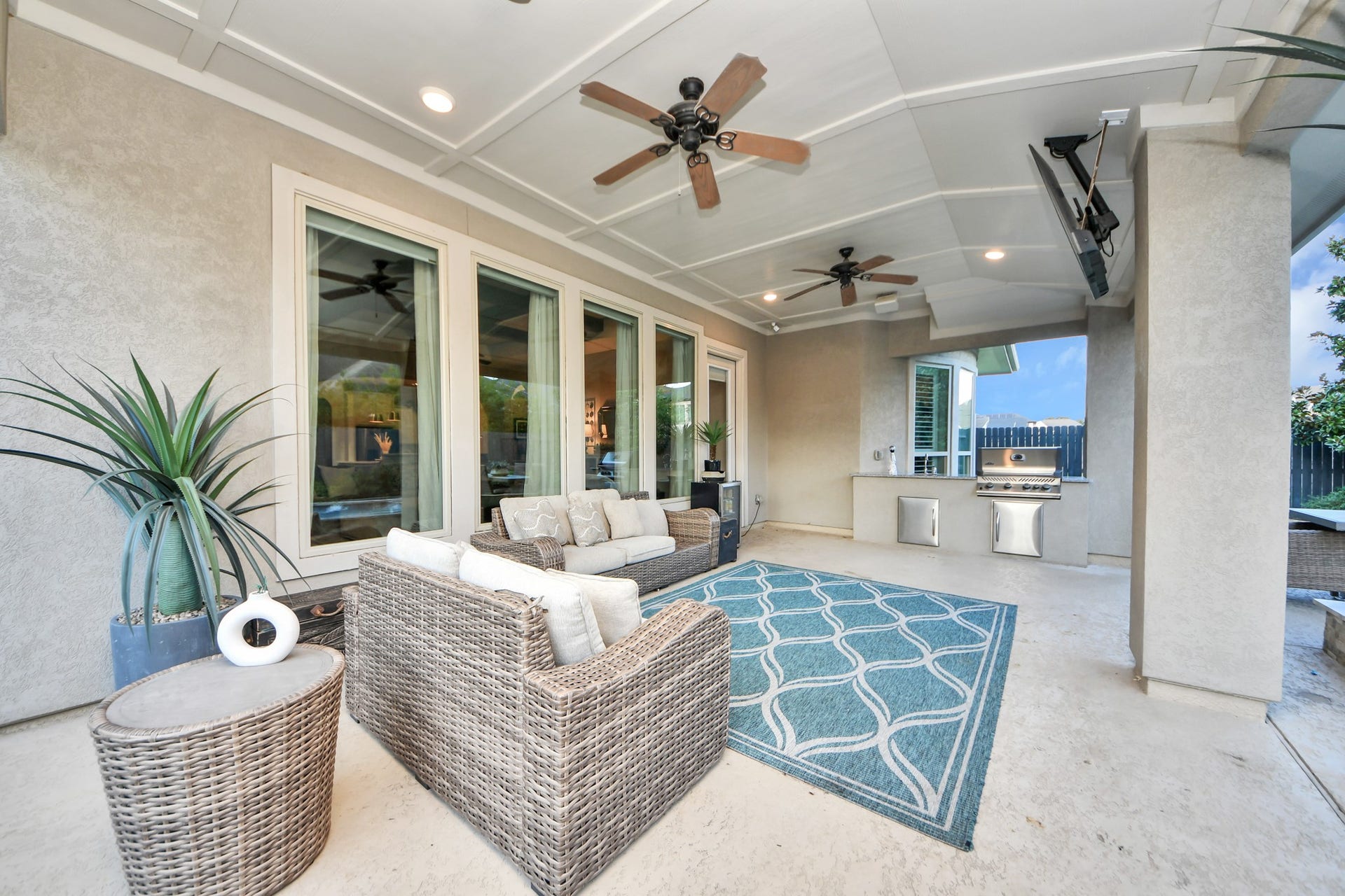 12821 N Palomino Lake Circle, Cypress, TX 77429 Oversized covered back patio designed for entertaining, featuring a fully equipped outdoor kitchen with built-in gas grill and sink, spacious seating and dining areas, and plenty of room for year-round outdoor gatherings.