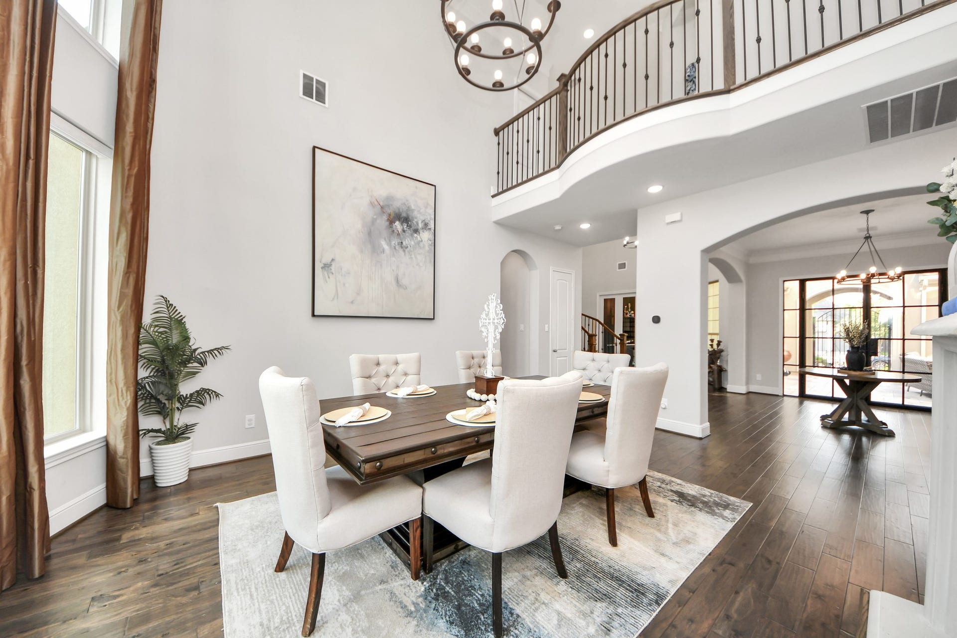 12821 N Palomino Lake Circle, Cypress, TX 77429 Elegant formal dining room featuring dramatic 20-foot ceilings, expansive windows, and an abundance of natural light flowing throughout the home.