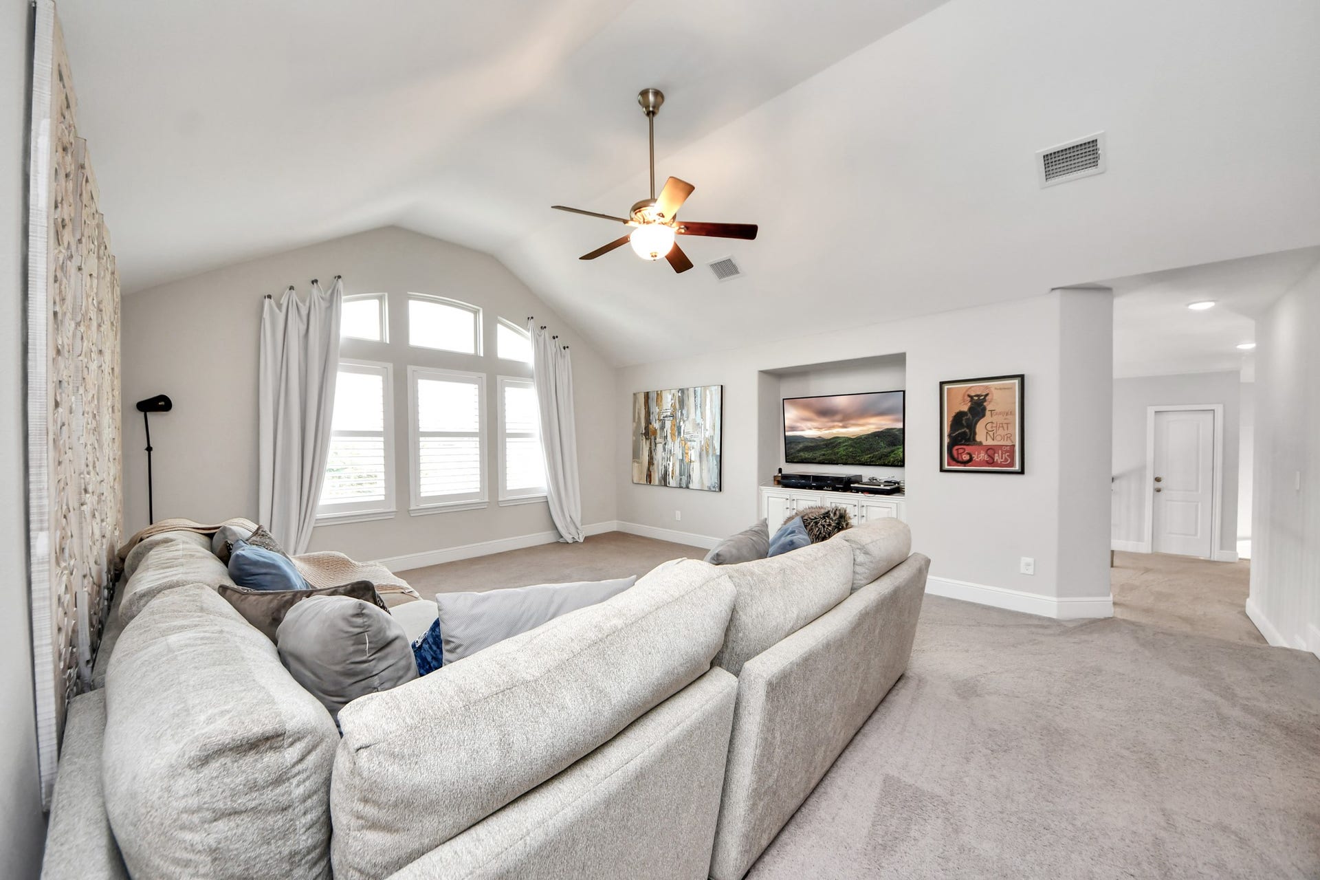 12821 N Palomino Lake Circle, Cypress, TX 77429 Oversized upstairs game room offering plenty of space for entertaining and relaxation, featuring plantation shutters, custom built-in cabinetry, and a spacious, versatile layout.