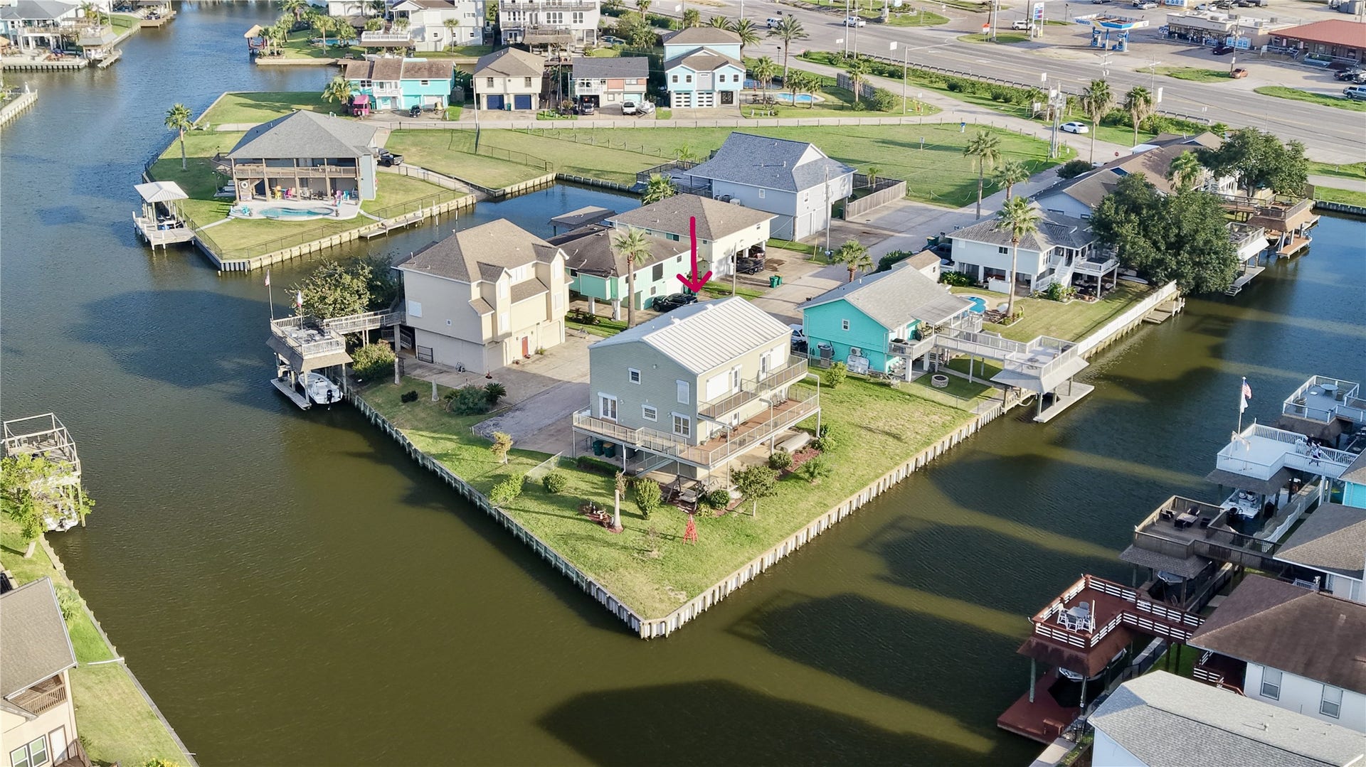 7 S Skimmer Street, La Marque, TX 77568 Less wide aerial showing the home's prime point position in Omega Bay, with open canal views, quick water access, and easy reach to shopping and dining just minutes away.