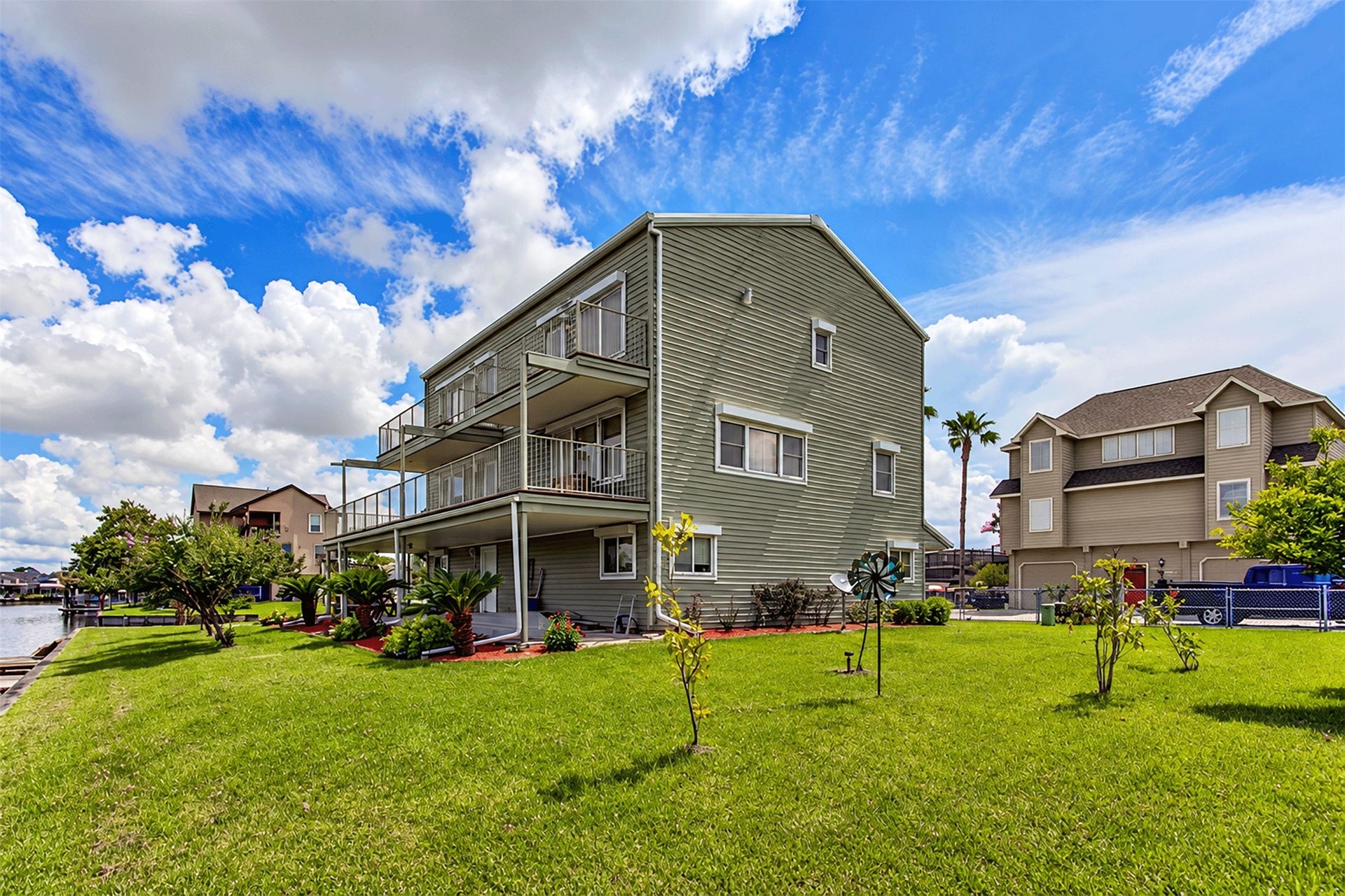 7 S Skimmer Street, La Marque, TX 77568 Expansive green lawn and multi-level decks overlooking the canal community.