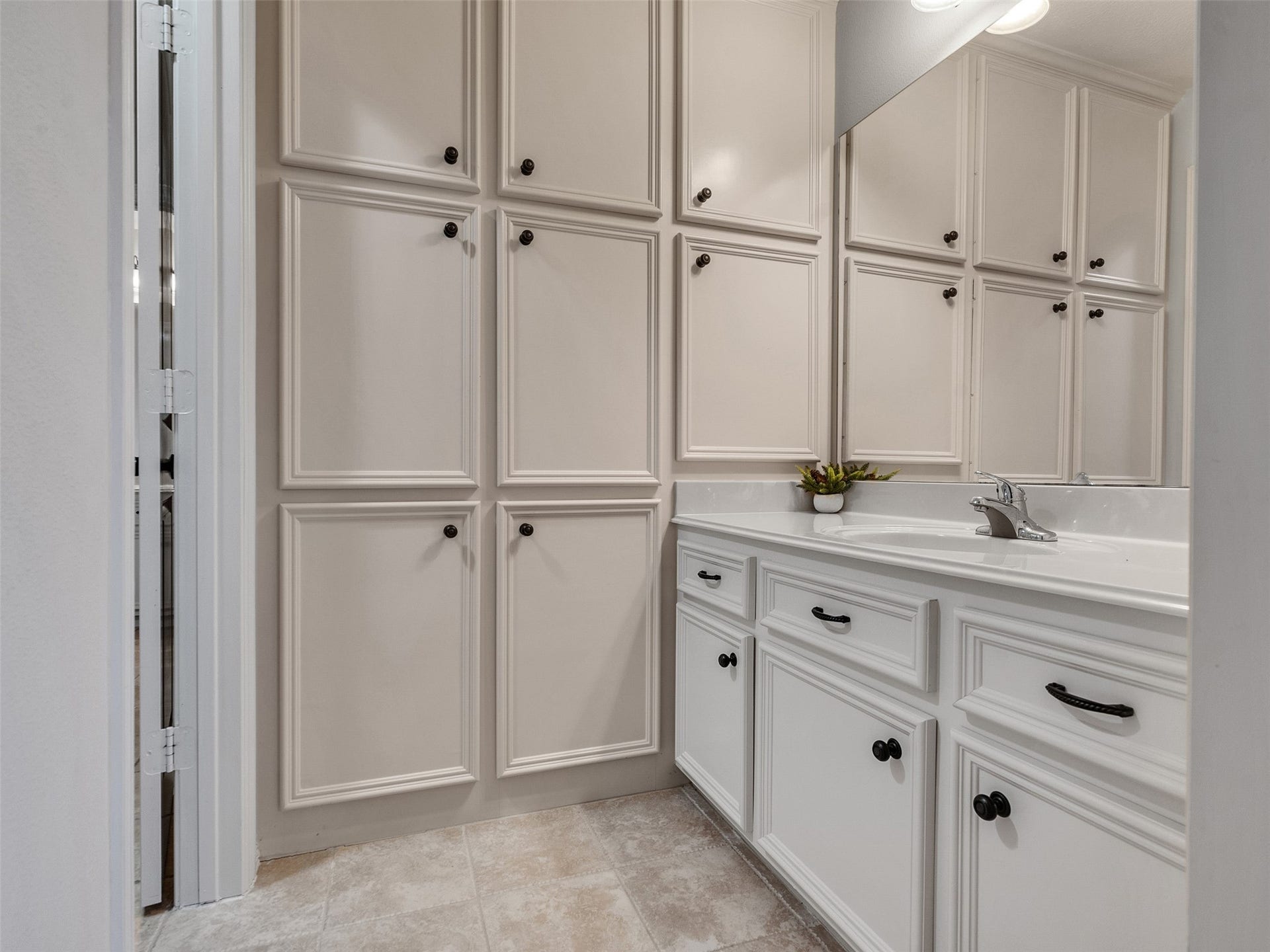 6914 Sandwedge Point Court, Spring, TX 77389 Bathroom with ample cabinetry, featuring white cabinets with dark handles, a sleek countertop, and a modern sink. The room is bright and has a clean, minimalist design.