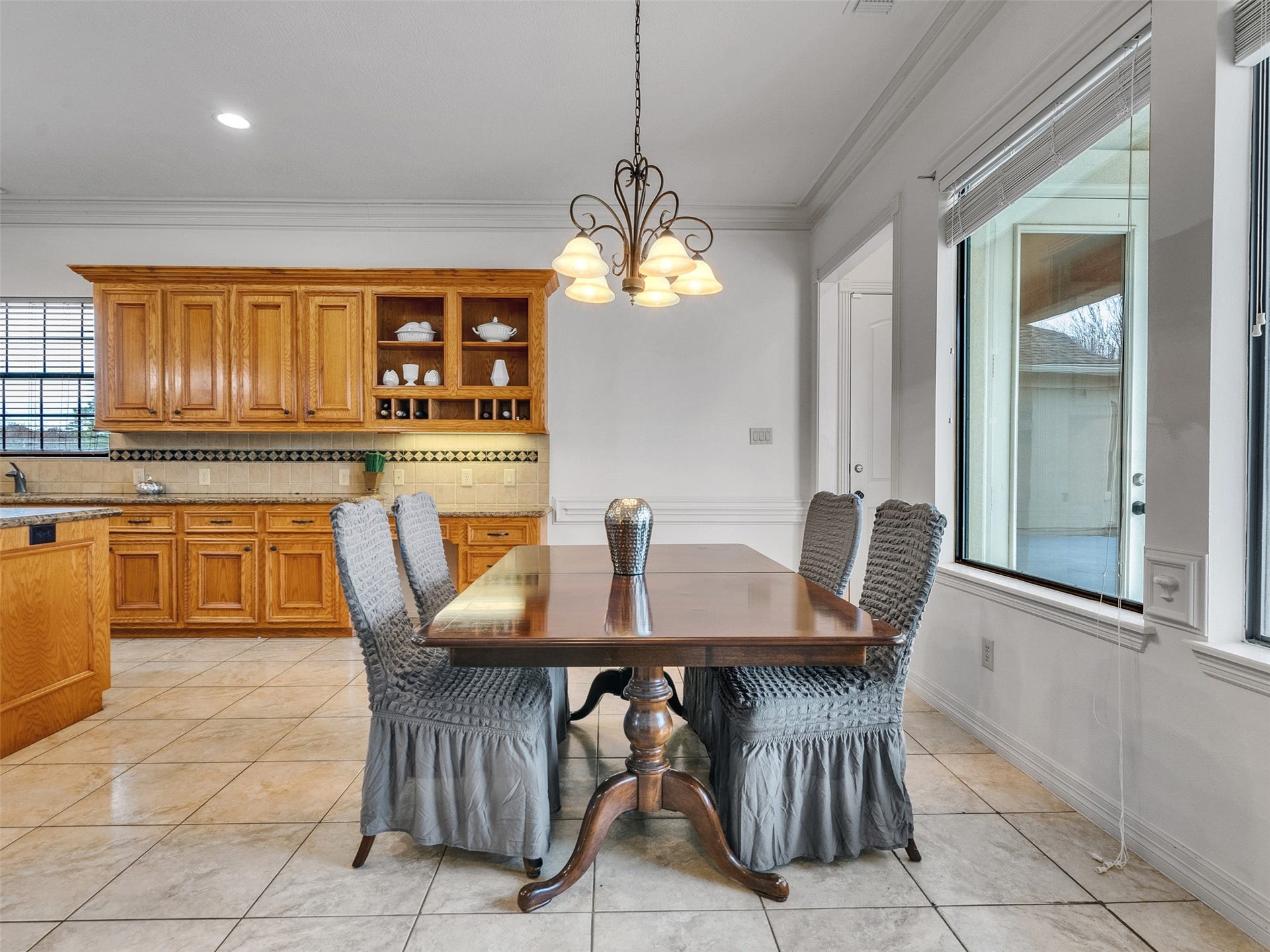 6914 Sandwedge Point Court, Spring, TX 77389 This bright dining area features a wooden table with elegant chairs, large windows for natural light, and an adjacent kitchen with ample cabinetry and granite countertops, perfect for hosting and family meals.