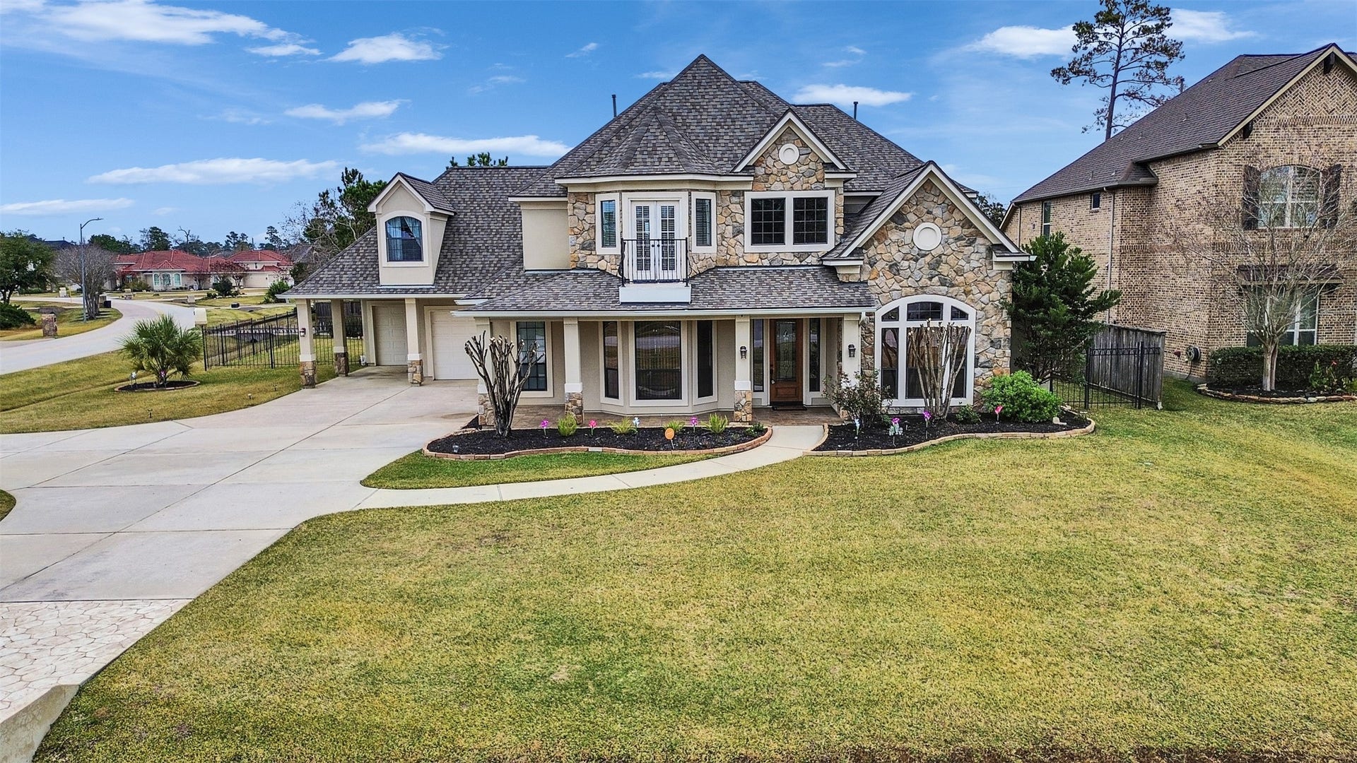 6914 Sandwedge Point Court, Spring, TX 77389 This beautiful two-story home features a charming stone facade, large windows, and a welcoming front porch. It's set on a spacious, well-maintained lawn with a curved driveway leading to a side garage. Located in a quiet neighborhood, it offers a blend of elegance and comfort.