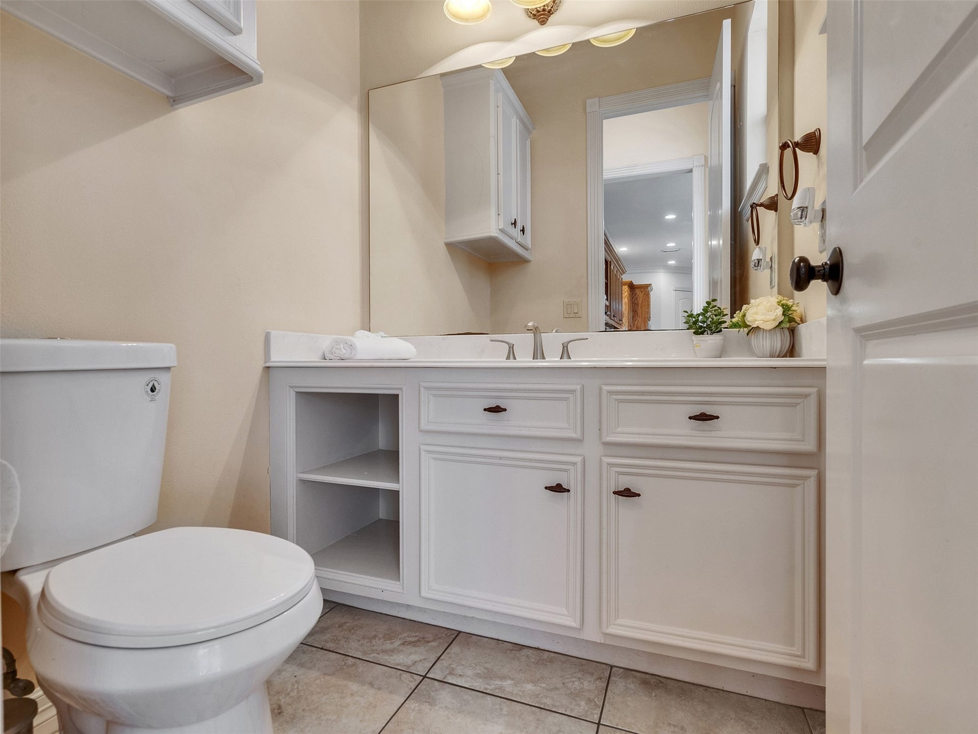 6914 Sandwedge Point Court, Spring, TX 77389 This is a clean, well-lit bathroom featuring a double sink vanity with ample storage, a large mirror, and a toilet. The neutral tones and tiled floor create a fresh and inviting atmosphere.