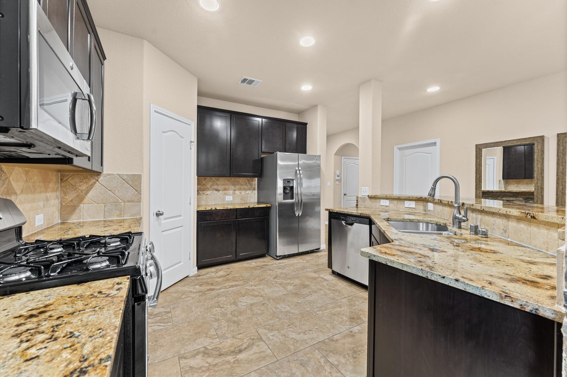 Next to the family room, a kitchen with a gas range and cooktop.