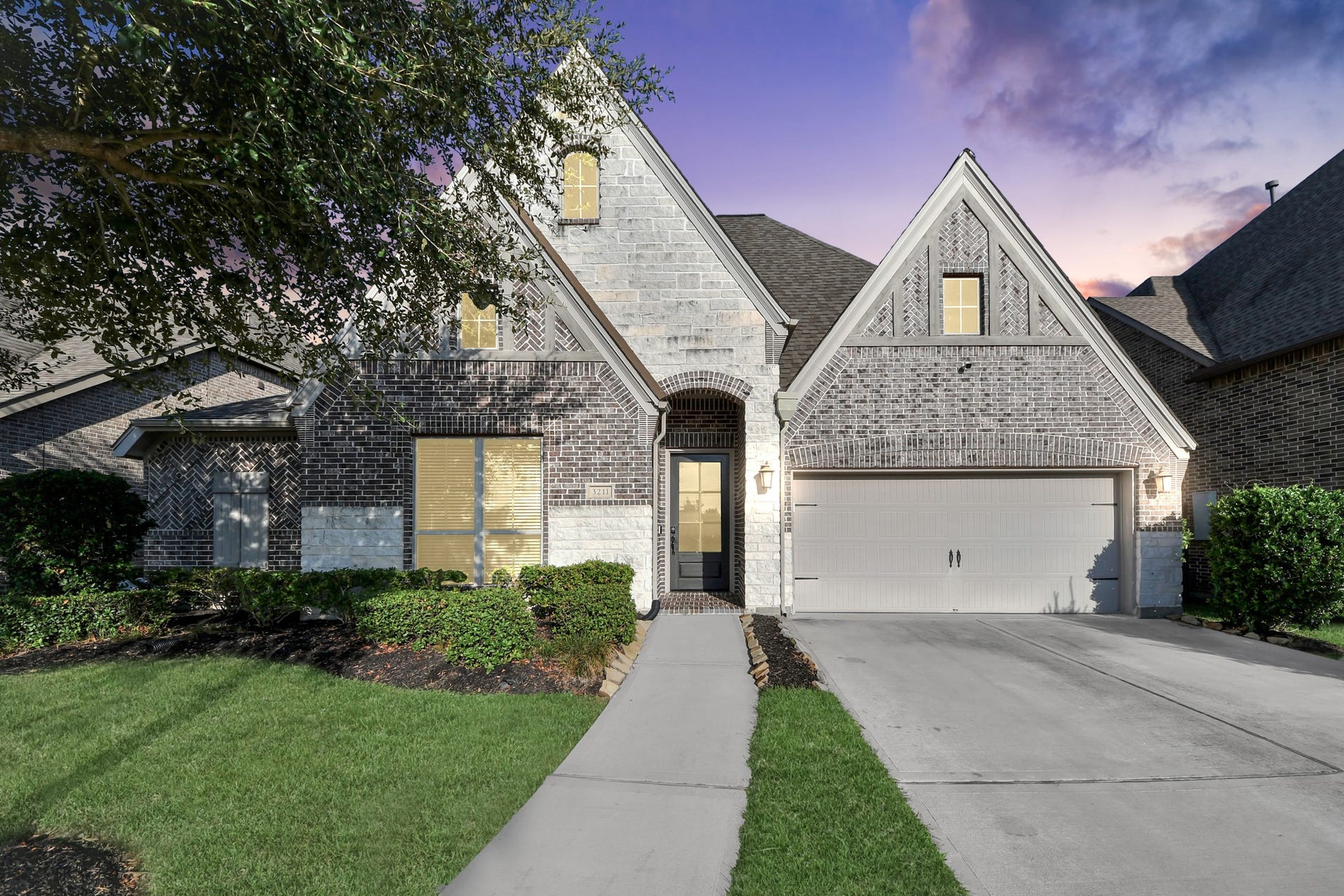 3211 Sweet Audrey Lane, Richmond, TX 77406 Warm evening glows will highlight the stone accents, arched entry, and manicured front beds.