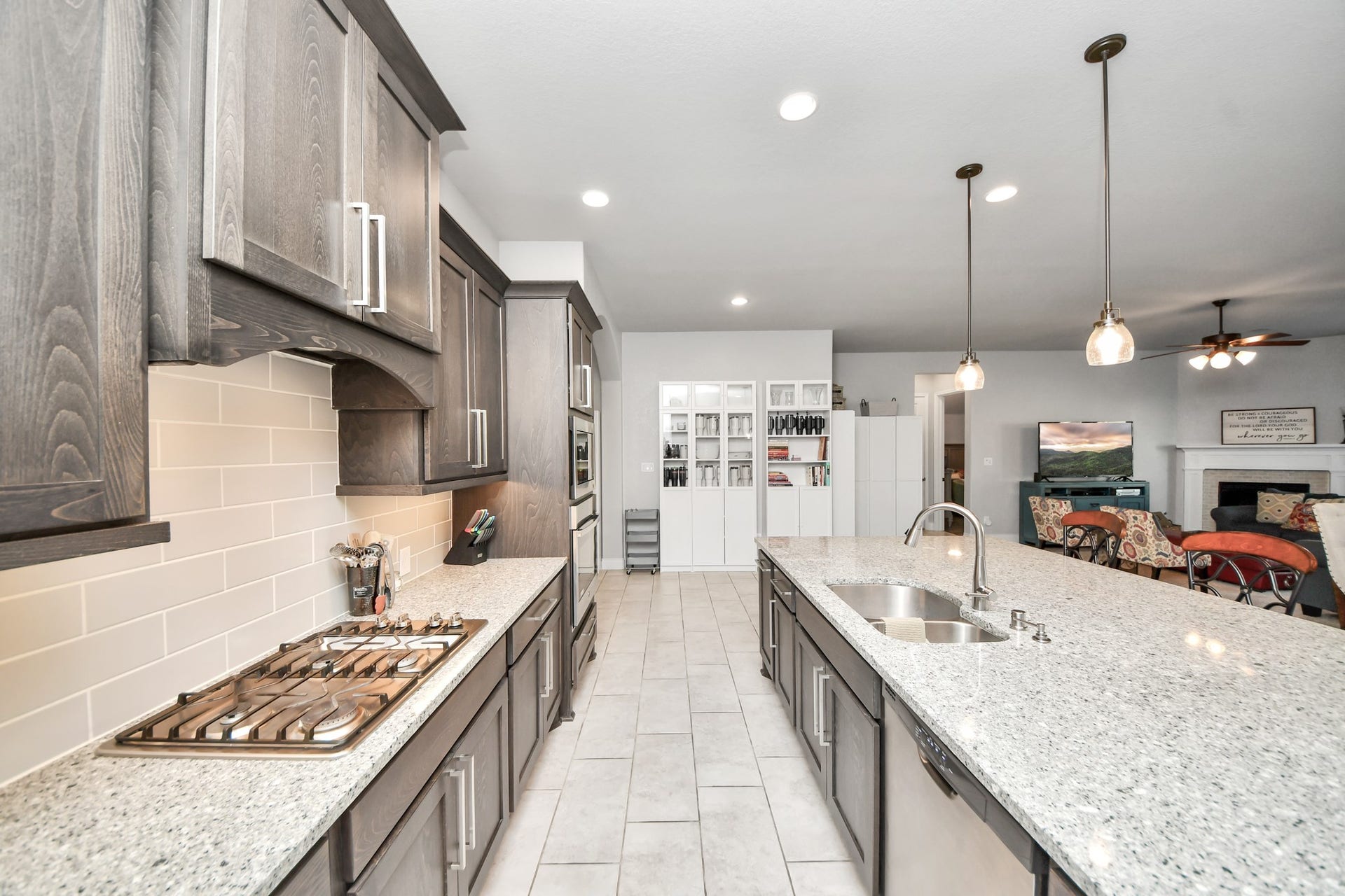 3211 Sweet Audrey Lane, Richmond, TX 77406 Gas cooktop with tile backsplash, abundant upper and lower cabinets, and long stretches of light stone countertop.