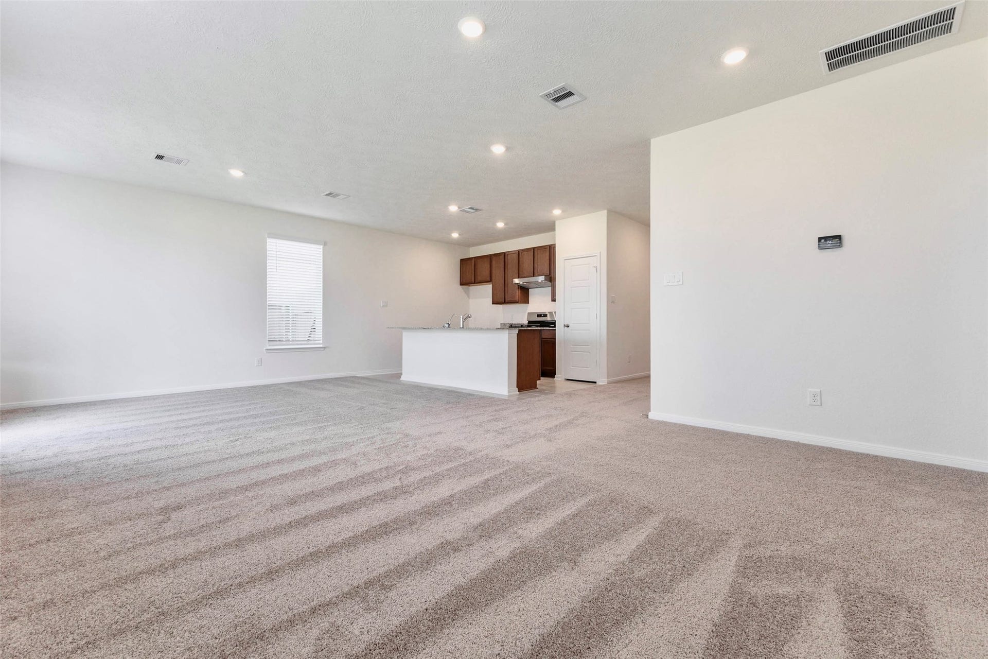 A wide view highlights how the family room, dining area and kitchen flow together.