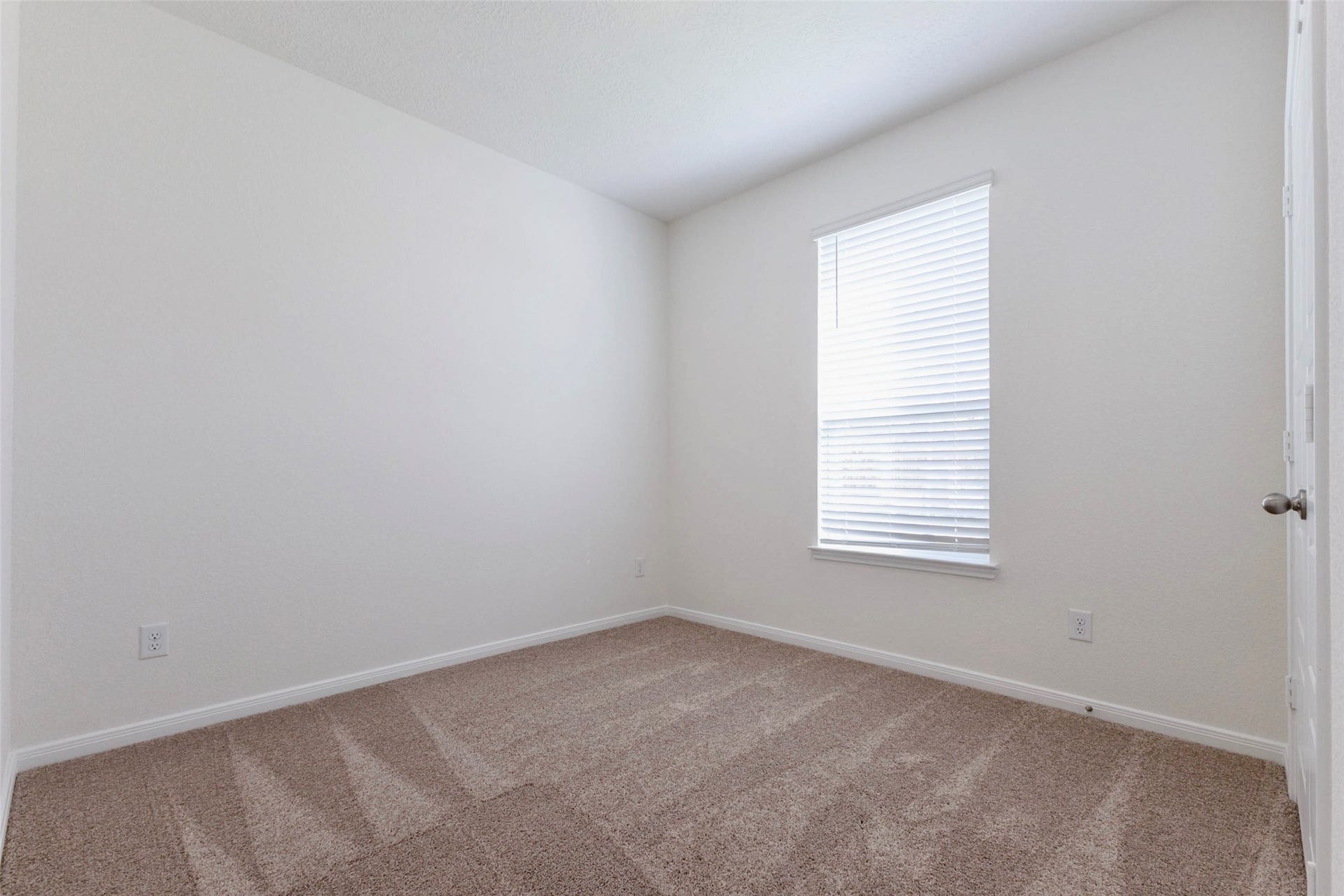 A second secondary bedroom offers plush carpet and natural light.
