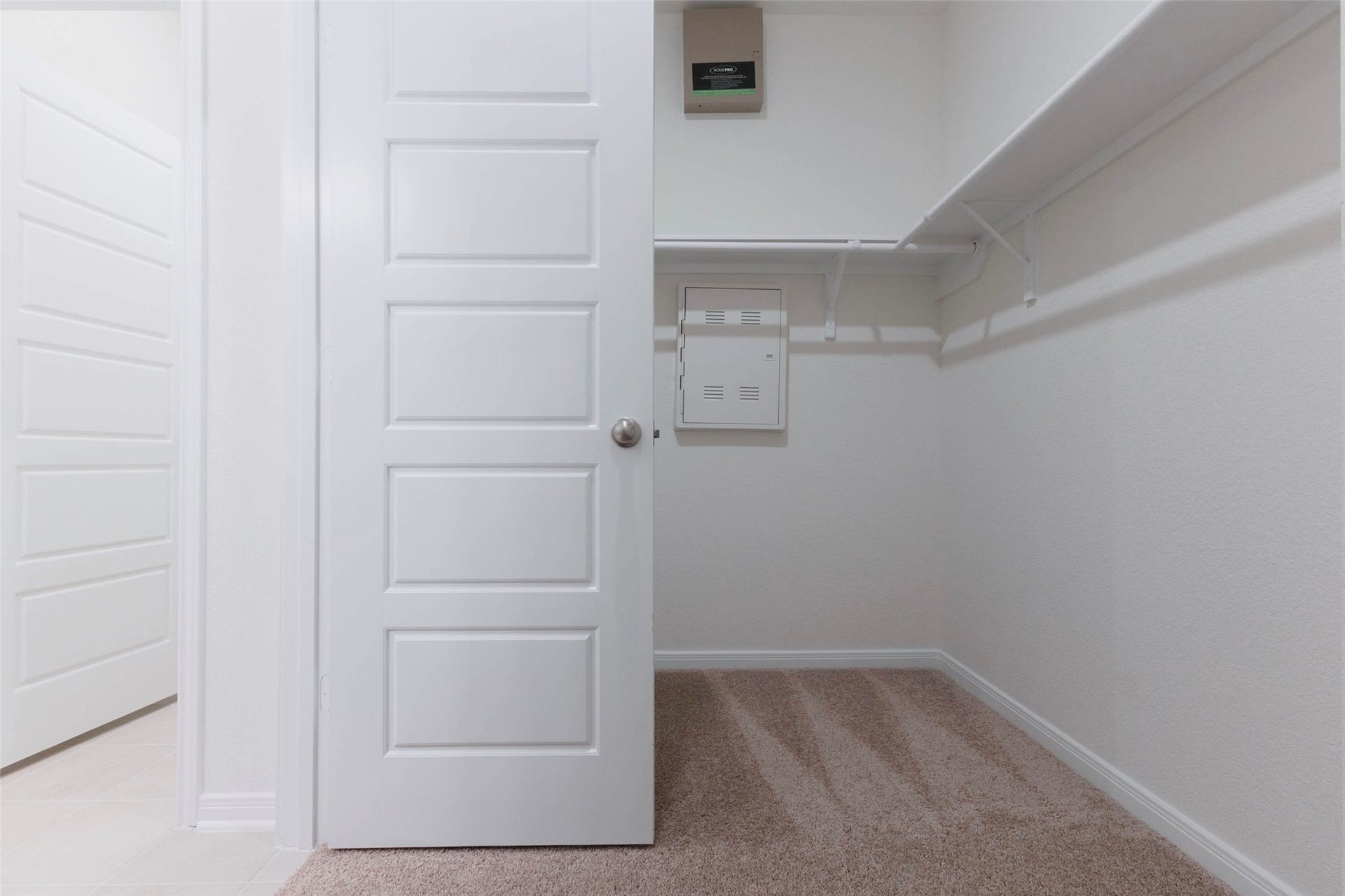 The primary walk in closet offers shelving and hanging space on two walls.