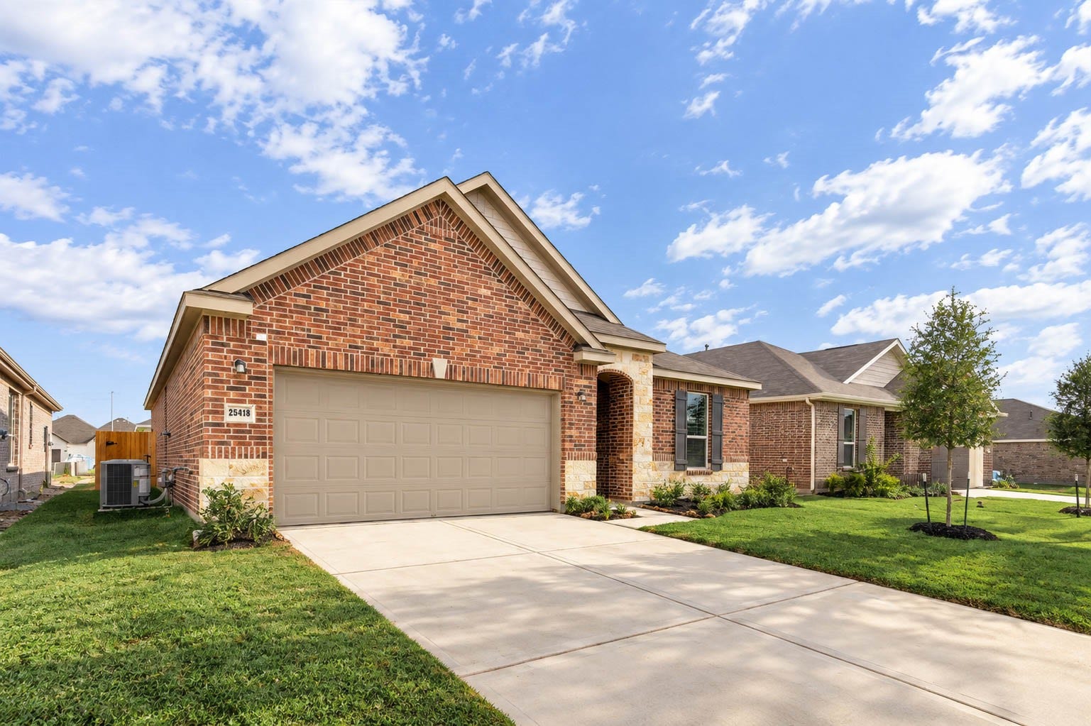 An alternate view of the front elevation and wide driveway.