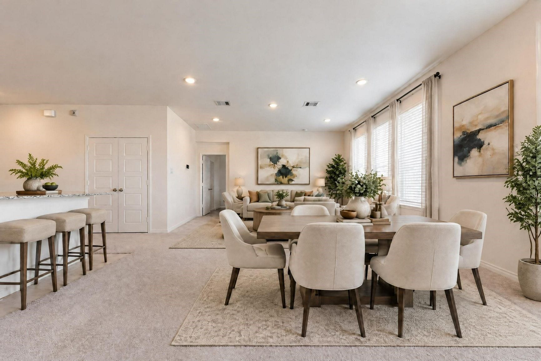 Virtually staged. The main living area is shown with island seating and a dining table beneath a wall of three windows.