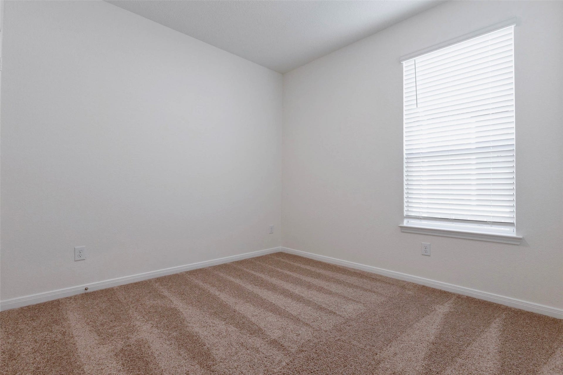 Another second secondary bedroom offers plush carpet and natural light.