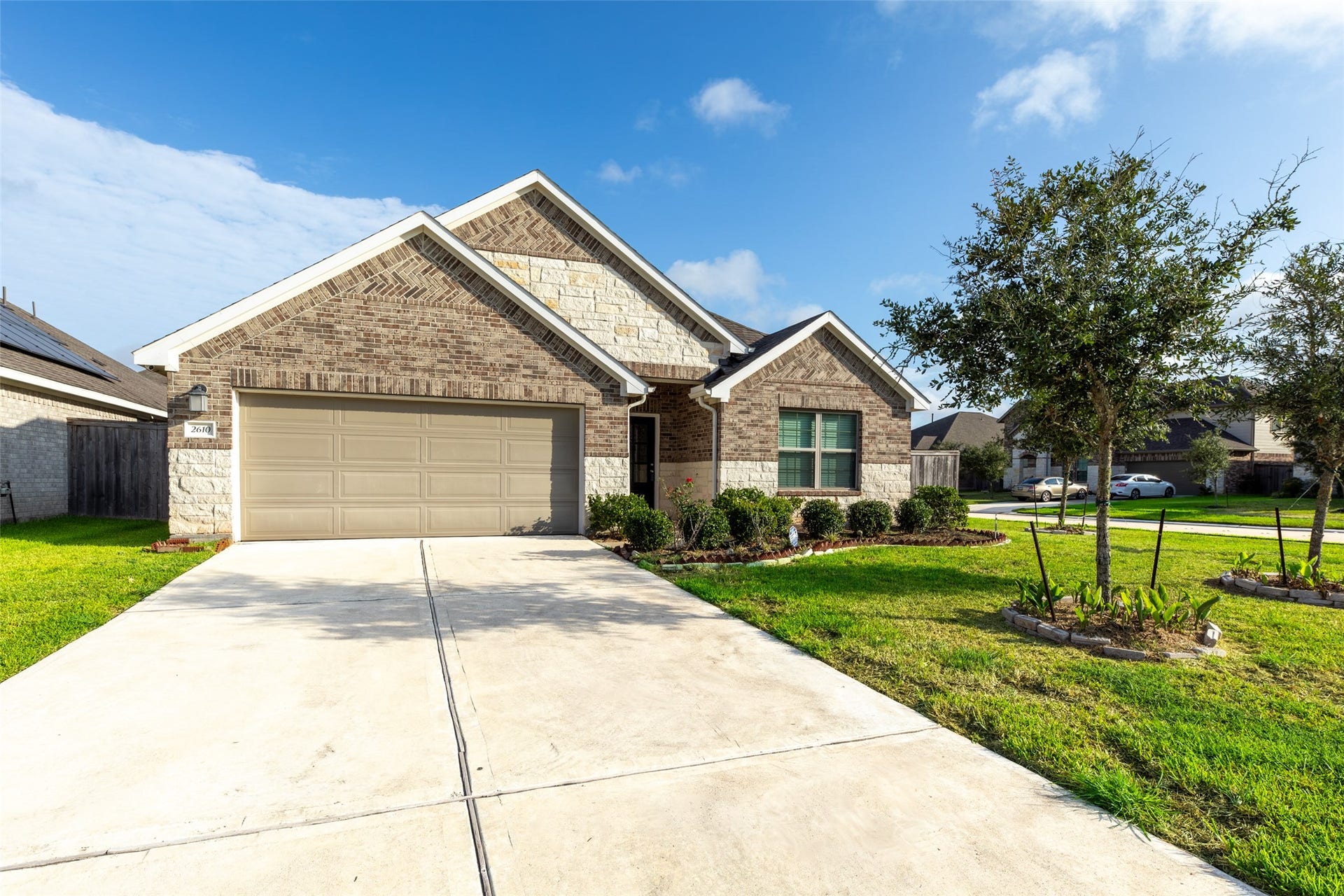 2610 Blue Abbot Drive, Fresno, TX 77545 Mix of brick and stone exterior, featuring a long driveway and manicured front yard landscaping.