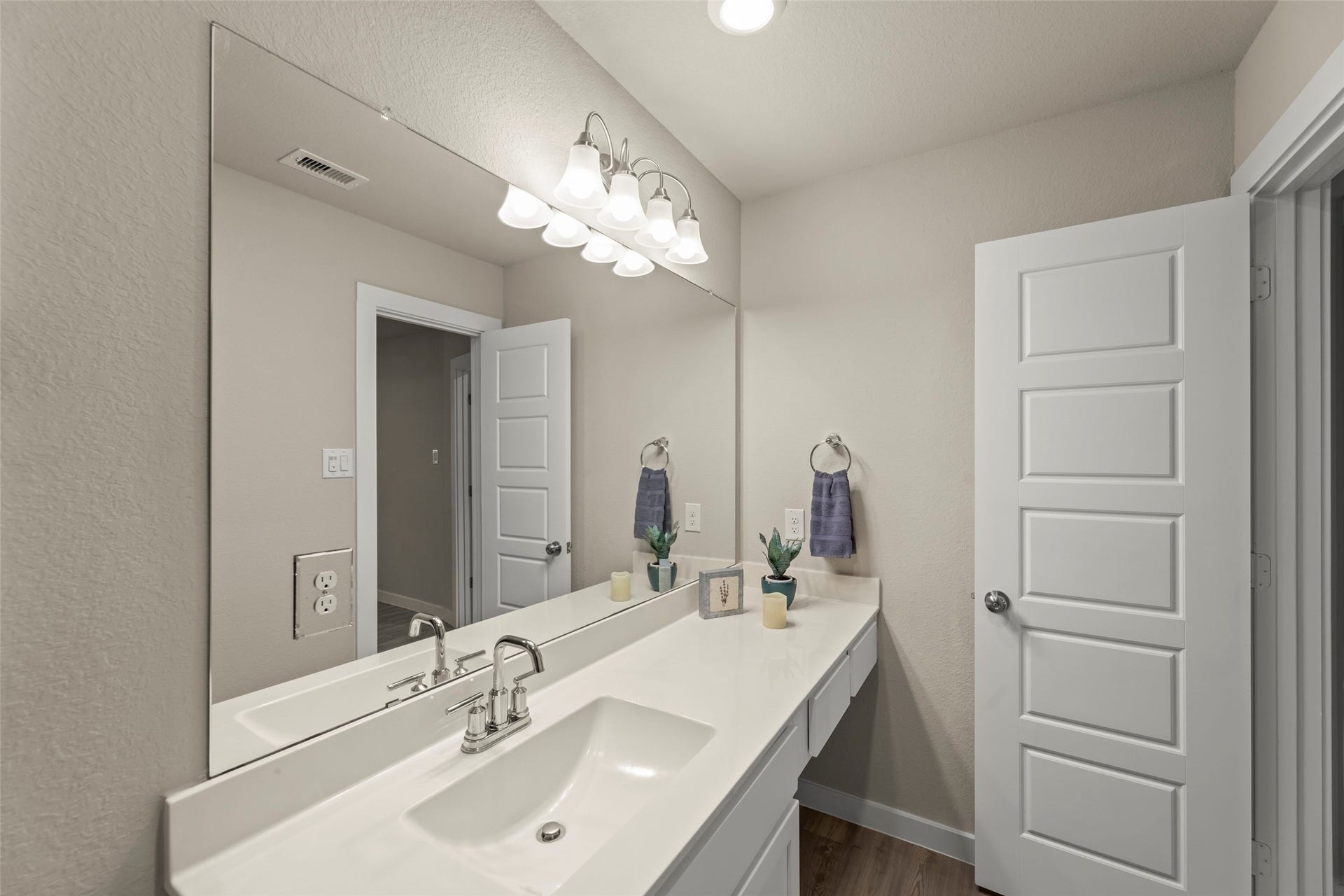2610 Blue Abbot Drive, Fresno, TX 77545 Contemporary bathroom featuring a sleek vanity with ample counter space, a large mirror, and stylish lighting fixtures.