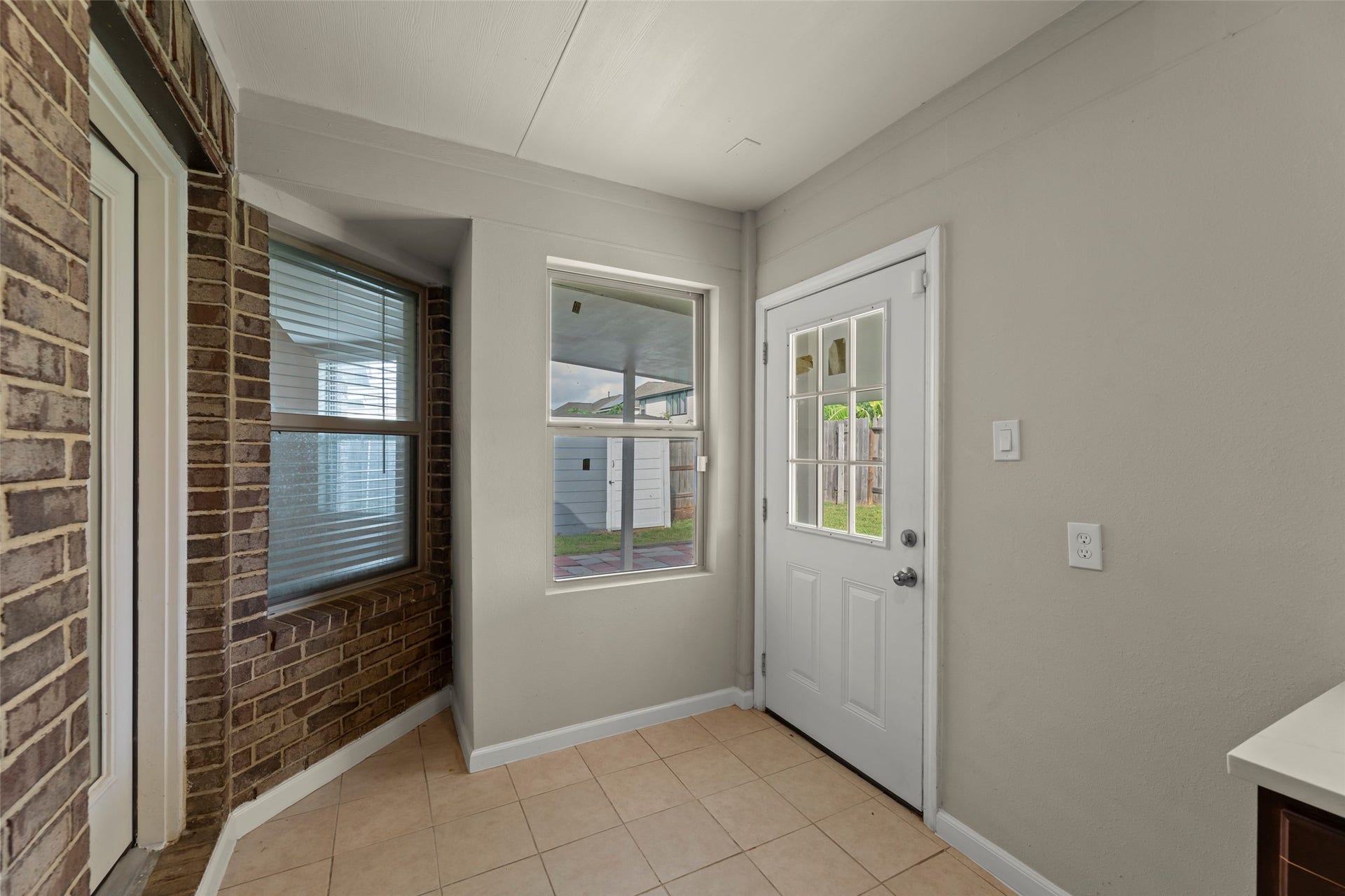 2610 Blue Abbot Drive, Fresno, TX 77545 Entryway featuring a mix of brick and neutral tones, with a windowed door that invites natural light and leads to a cozy outdoor space.