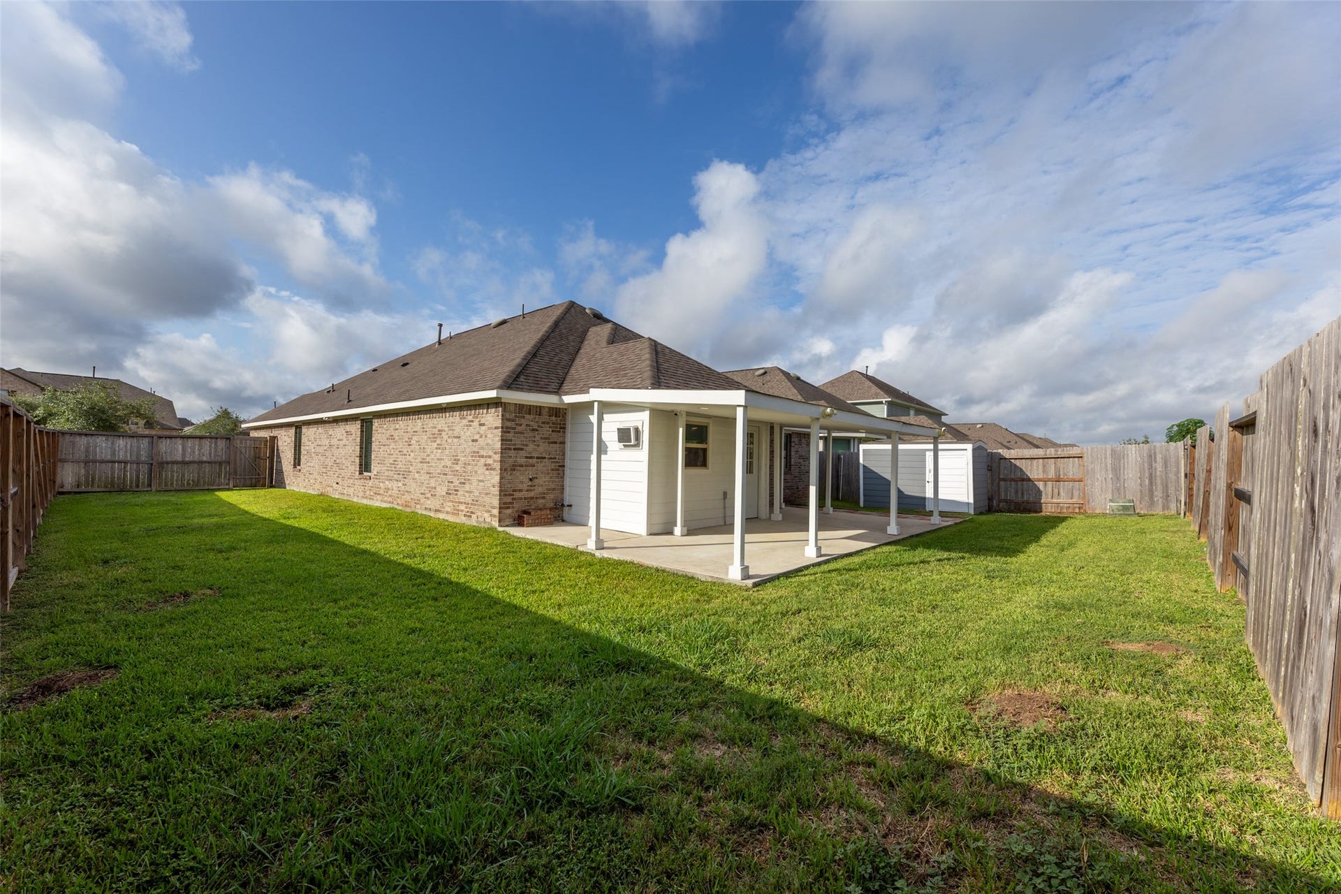 2610 Blue Abbot Drive, Fresno, TX 77545 Spacious backyard with a covered patio, perfect for outdoor gatherings and relaxation in a fenced setting.