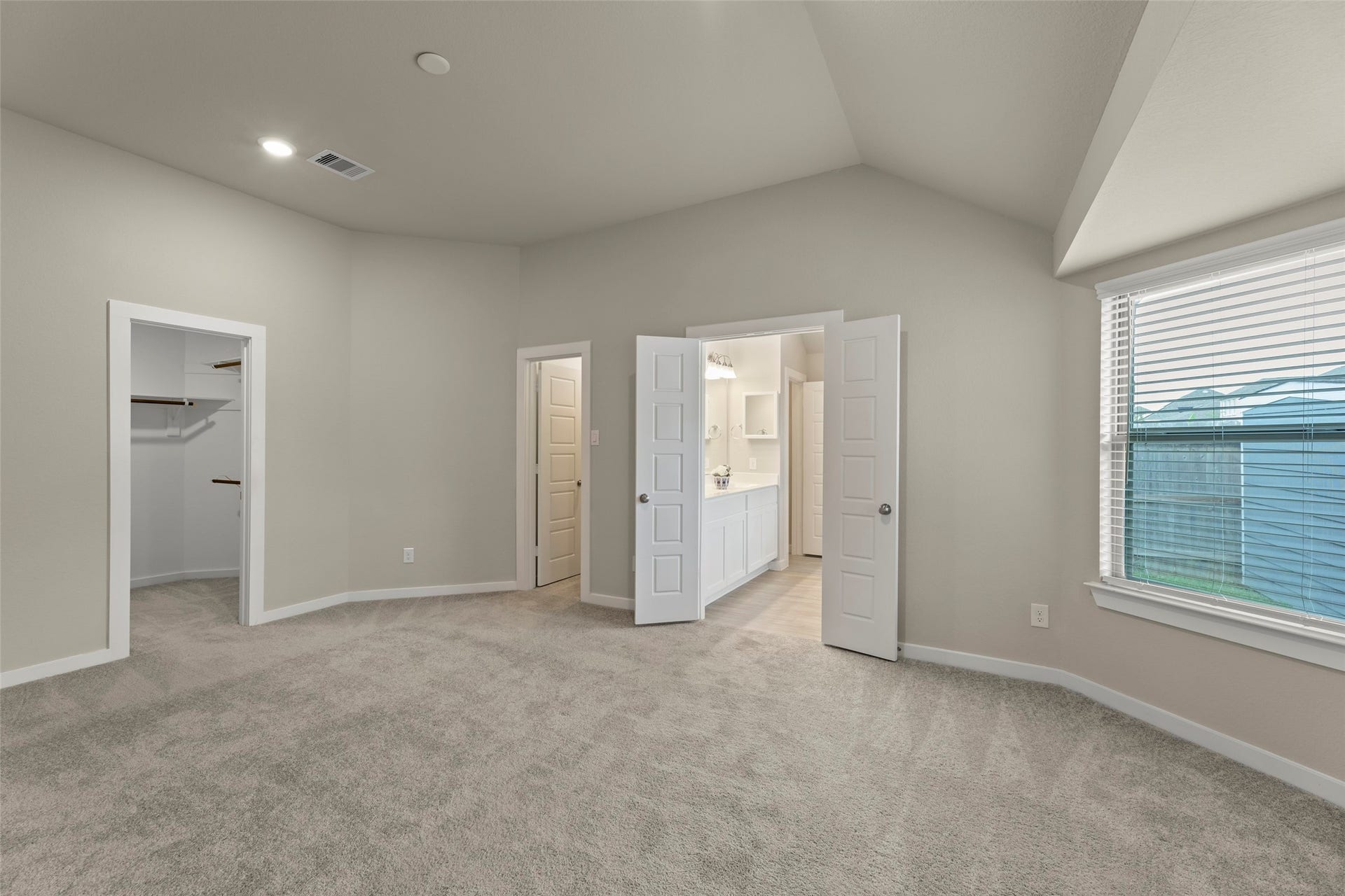 2610 Blue Abbot Drive, Fresno, TX 77545 Primary bedroom with plush carpeting, featuring a walk-in closet and an en-suite bathroom, illuminated by natural light from a large window.