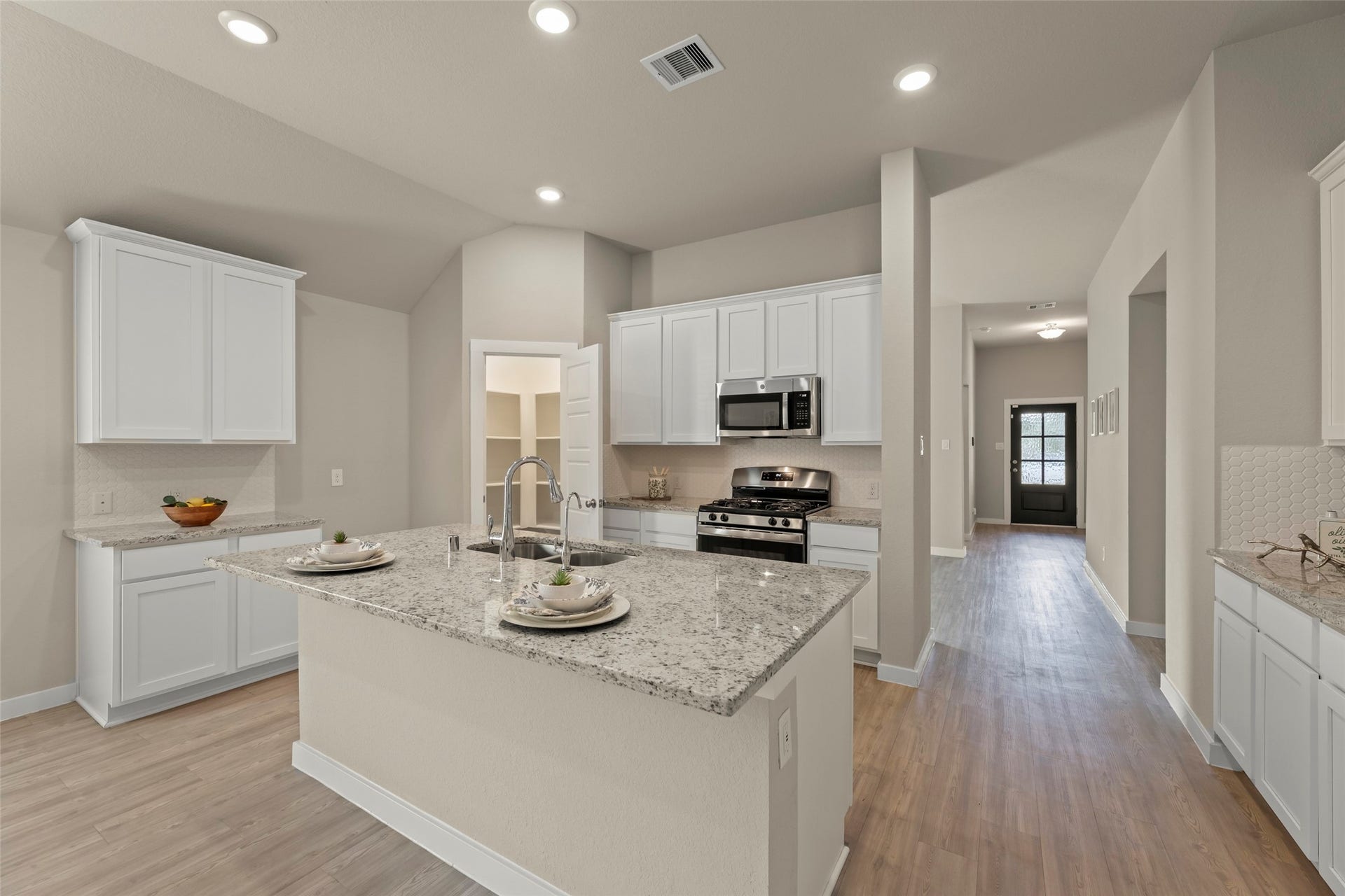 2610 Blue Abbot Drive, Fresno, TX 77545 Granite countertops, stainless steel appliances, and elegant white cabinetry, all complemented by warm wood flooring and ample natural light.
