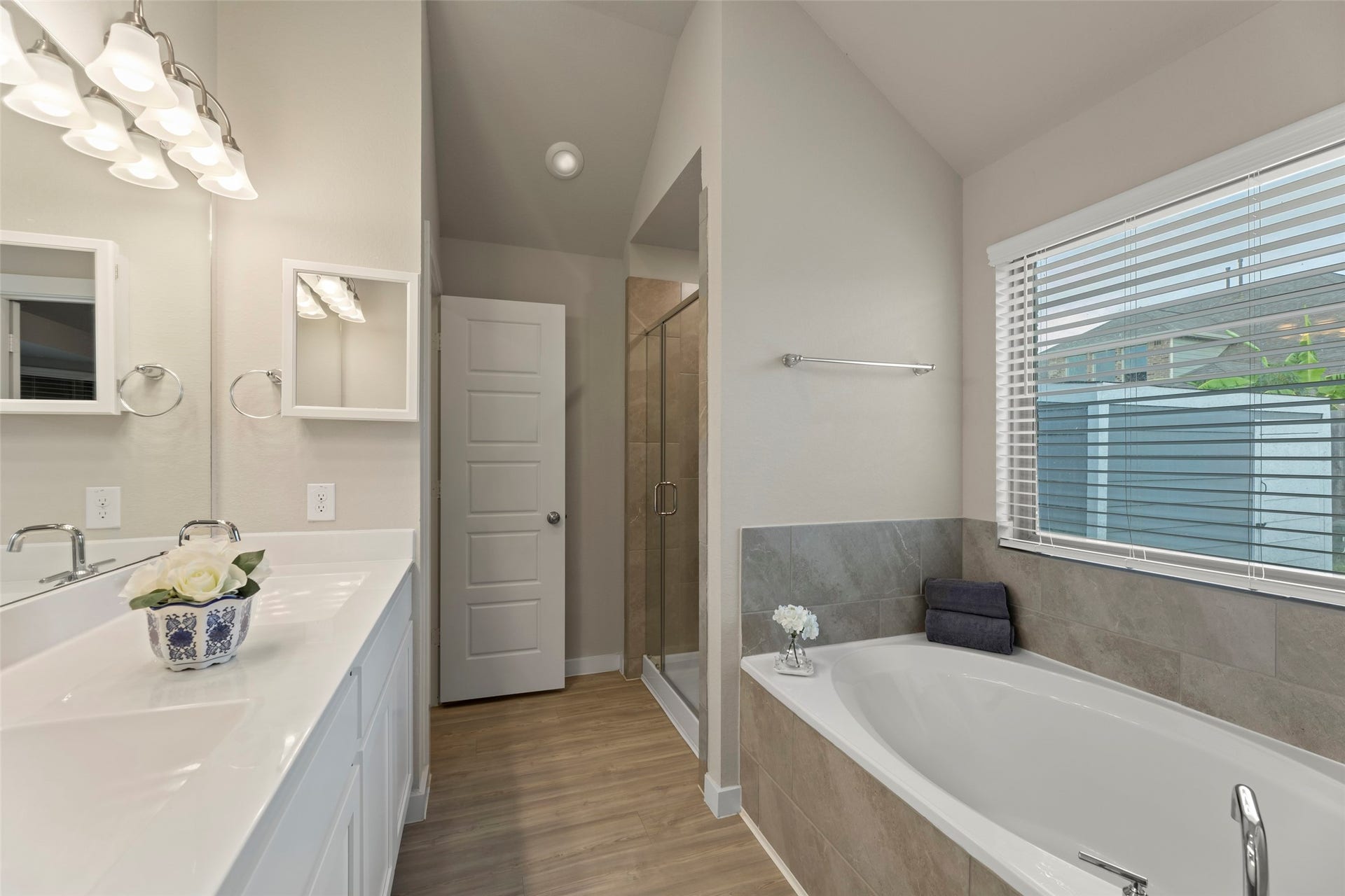 2610 Blue Abbot Drive, Fresno, TX 77545 Luxury in this elegant bathroom featuring a spacious soaking tub, dual sinks with modern fixtures, and a walk-in shower, all bathed in natural light from large windows.