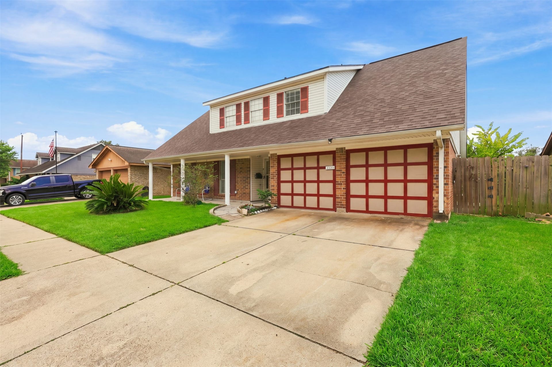 Charming curb appeal with a wide driveway, attached garage, and inviting covered front porch.