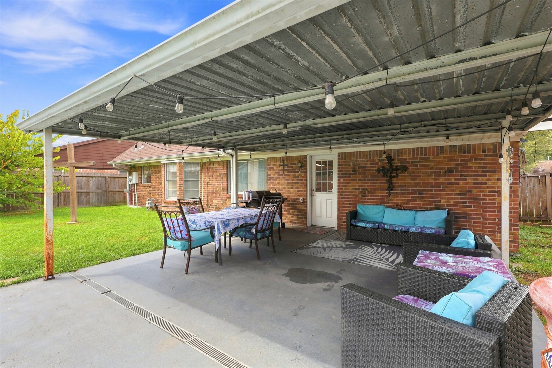 Covered backyard patio creates a shaded outdoor space perfect for relaxing or entertaining.