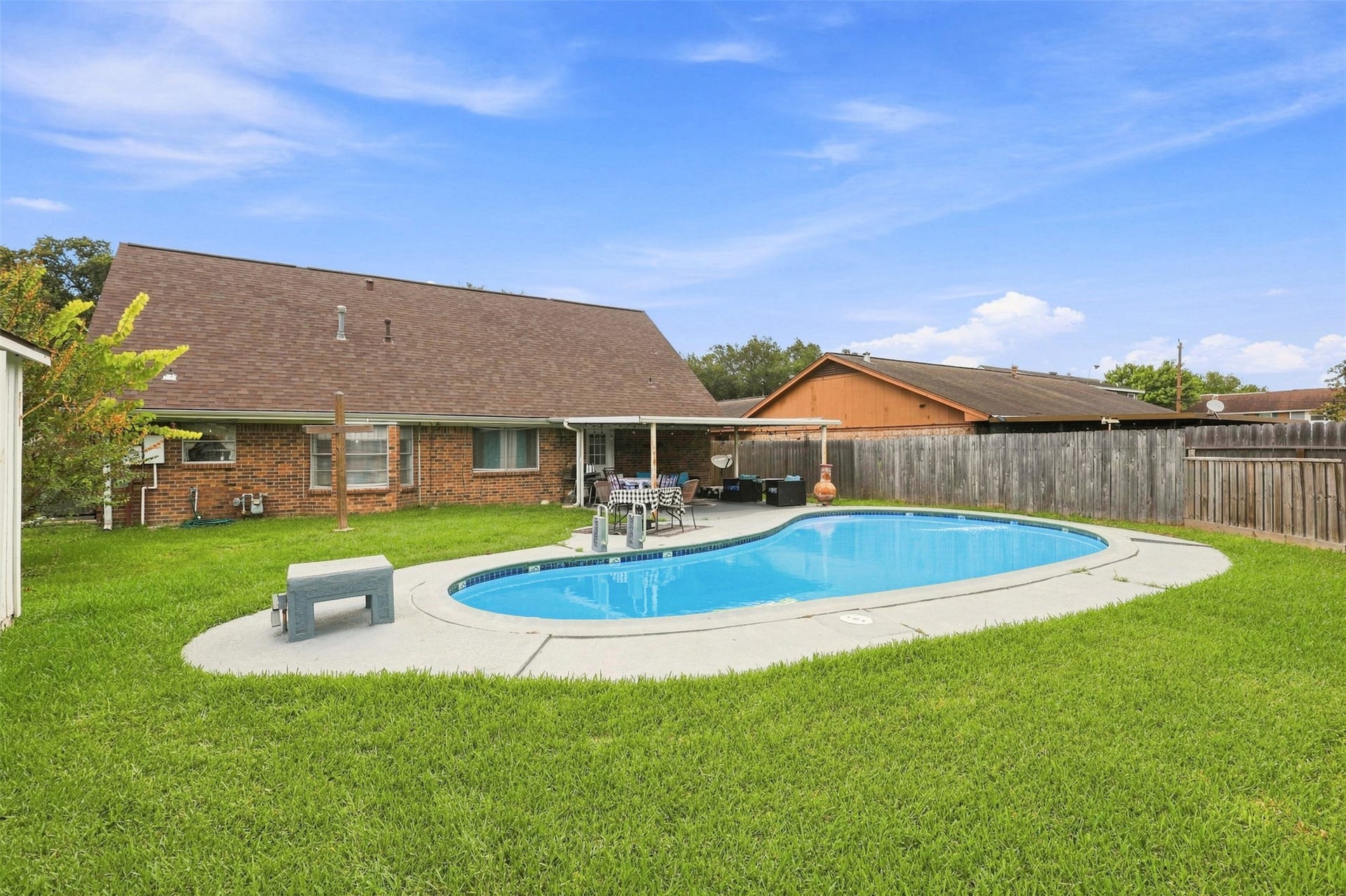 Another view of the private backyard retreat with plenty of lawn surrounding the pool.