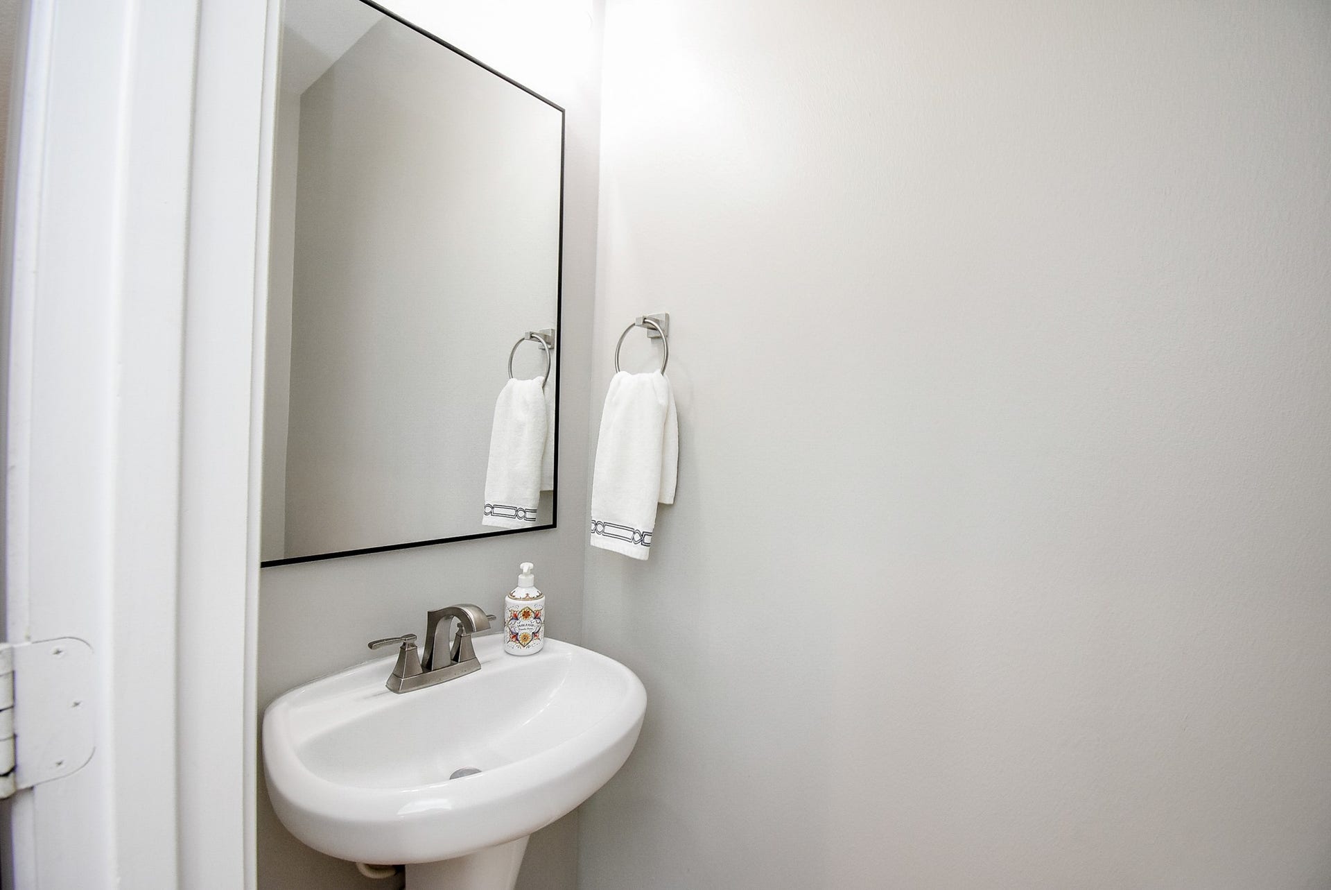 1334 Laura Hills Lane, Spring, TX 77386 Updated guest half bath with modern pedestal sink, black from mirror, updated vanity lights and fresh paint.