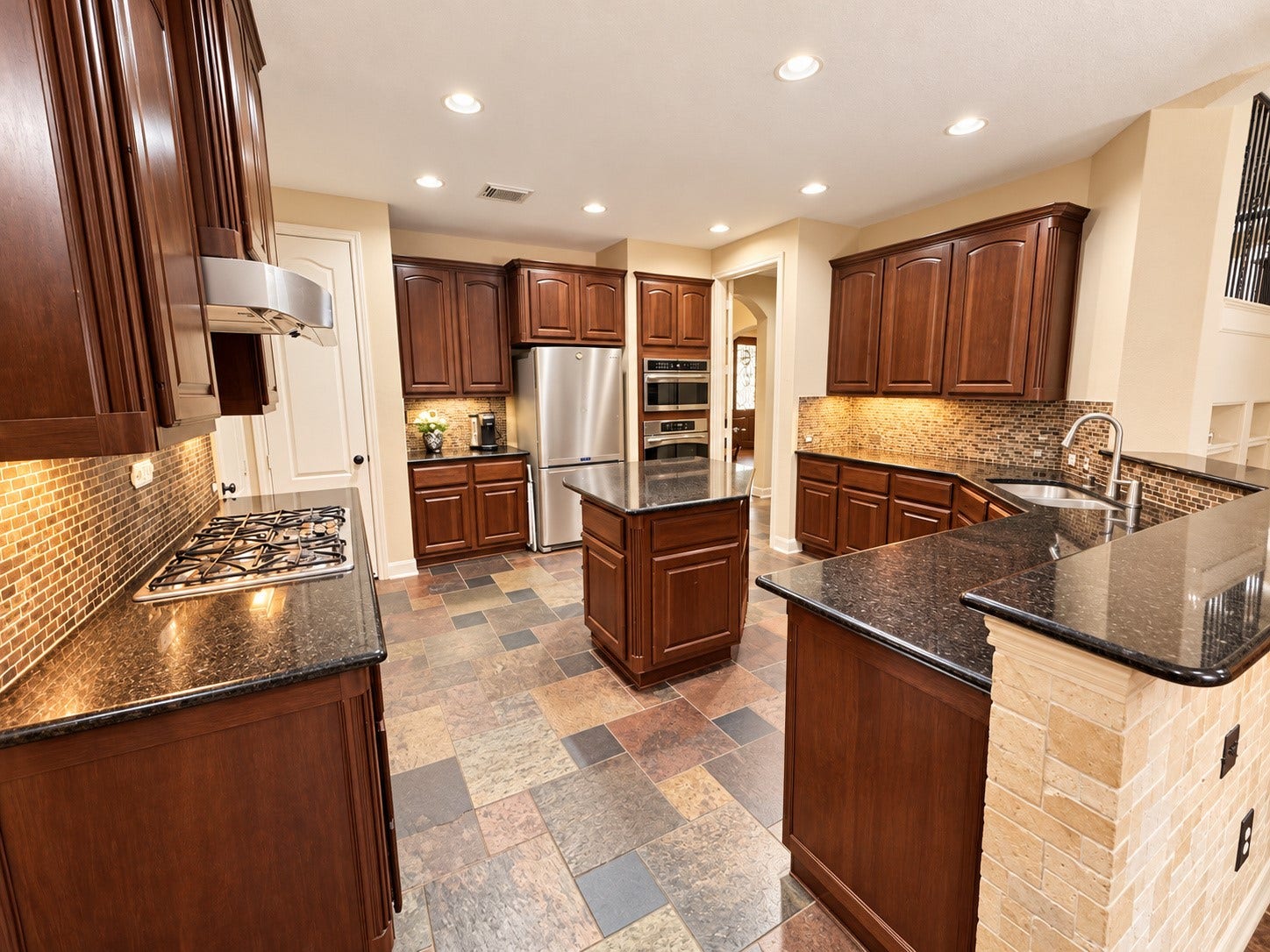 14215 Windy Crossing Lane, Humble, TX 77396 Beautifully appointed kitchen with extensive cabinetry, tile backsplash, and generous counter space.