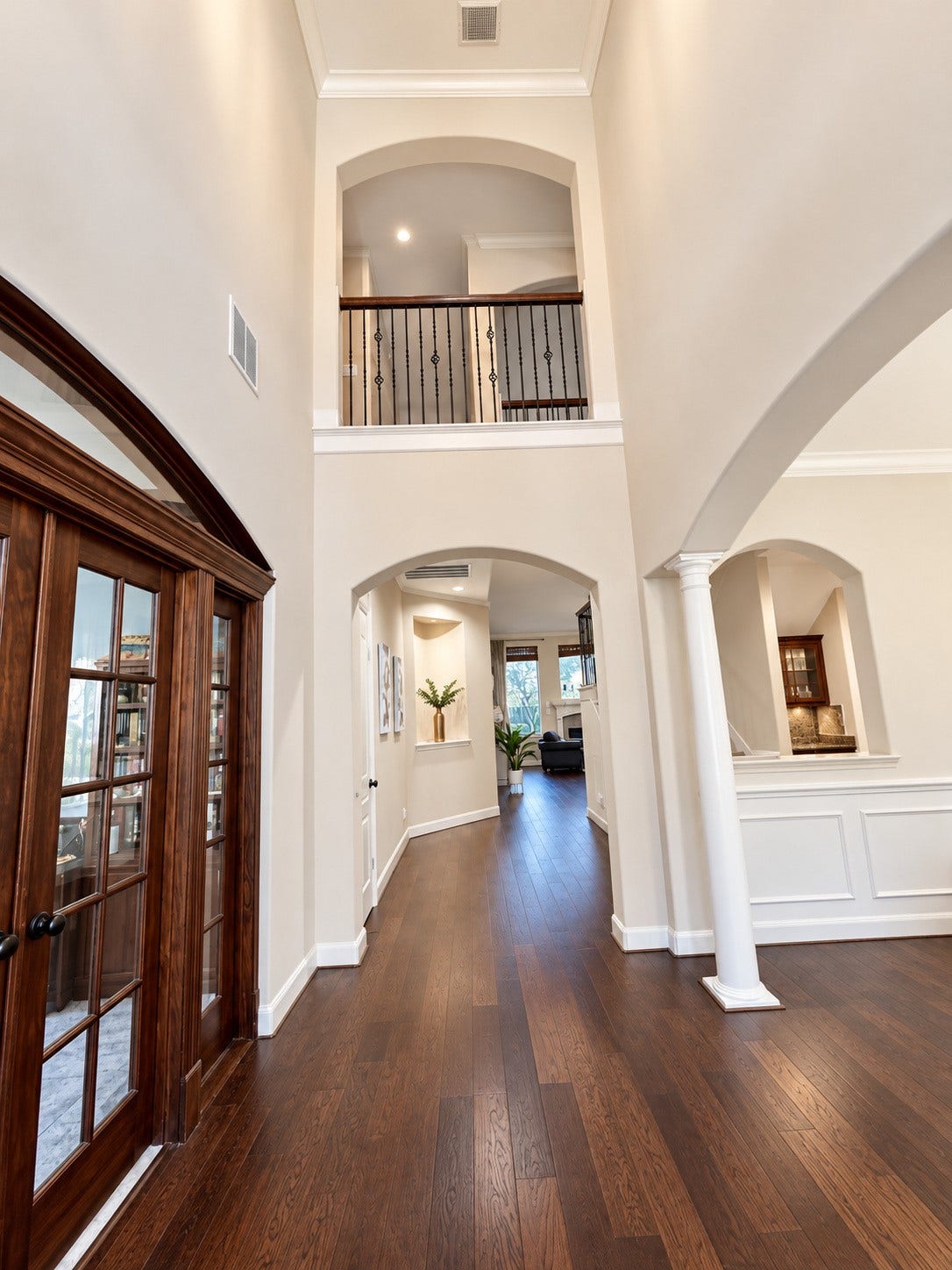 14215 Windy Crossing Lane, Humble, TX 77396 Impressive two-story entryway featuring soaring ceilings, graceful archways, and rich wood flooring.