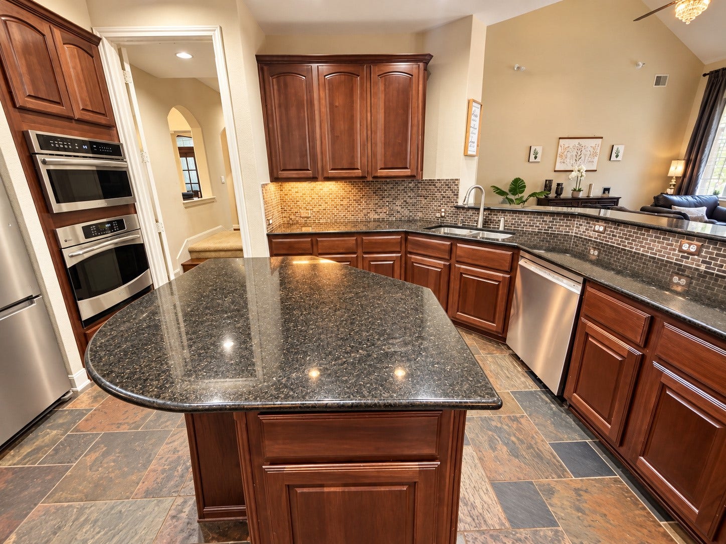 14215 Windy Crossing Lane, Humble, TX 77396 Spacious kitchen featuring rich wood cabinetry, dark countertops, stainless steel appliances, and a center island.