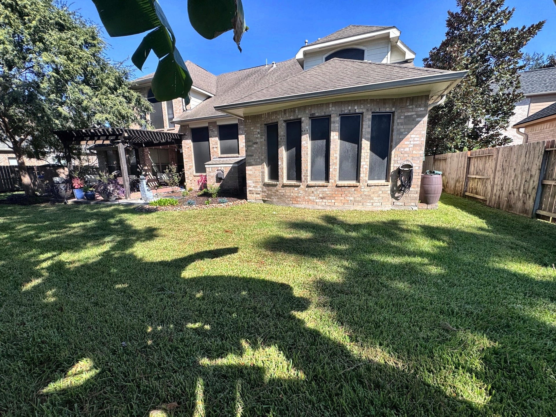 14215 Windy Crossing Lane, Humble, TX 77396 Generous backyard with mature trees, lush lawn, and space for outdoor activities and relaxation.