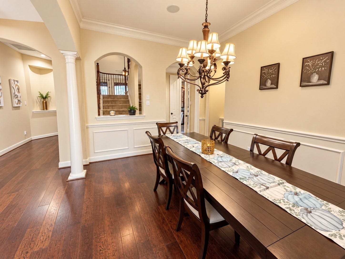 14215 Windy Crossing Lane, Humble, TX 77396 Warm and inviting formal dining room featuring rich wood floors, elegant molding, and a beautiful chandelierperfect for sharing meals and making memories.