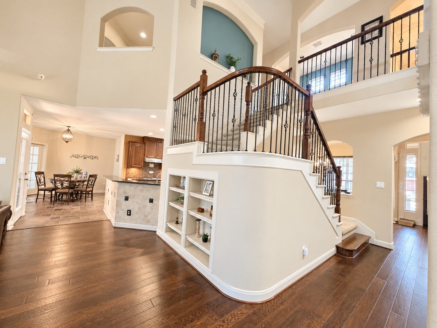 14215 Windy Crossing Lane, Humble, TX 77396 Elegant staircase with decorative wrought-iron balusters, rich wood railings, and carpeted steps.