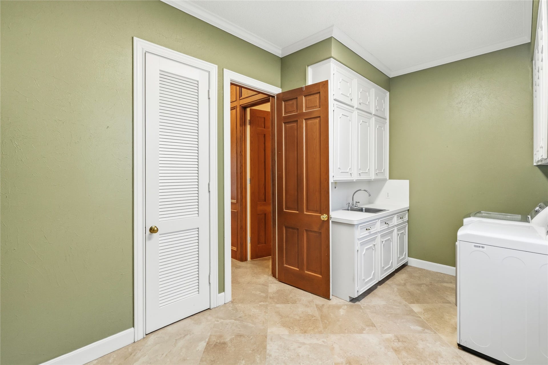 218 Bella Vista Drive, Richmond, TX 77406 Laundry room with cabinetry, a convenient sink, and washer-dryer setup.