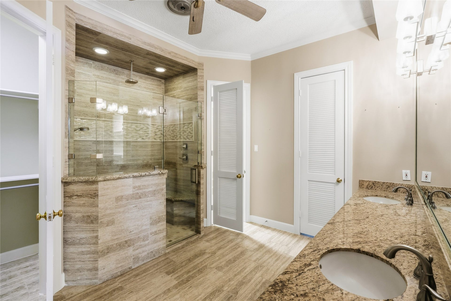 218 Bella Vista Drive, Richmond, TX 77406 Primary bathroom featuring a walk-in shower with modern glass doors, dual sinks with granite countertops.