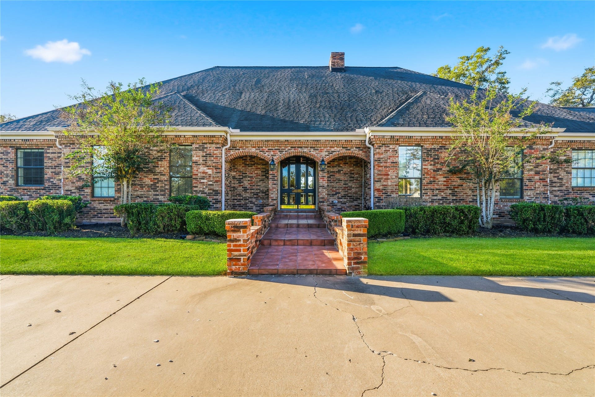 218 Bella Vista Drive, Richmond, TX 77406 Stunning single-story brick home with manicured landscaping, inviting entrance, and classic architectural details.
