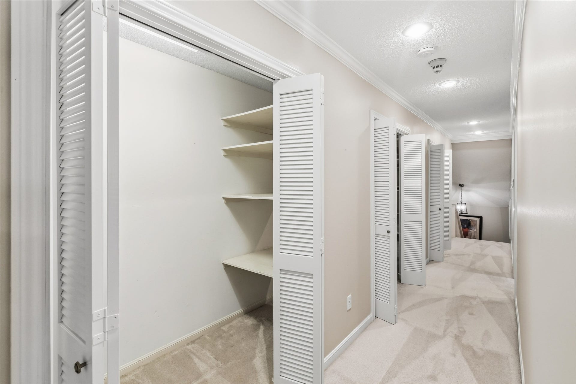 218 Bella Vista Drive, Richmond, TX 77406 A well-lit hallway with multiple closets featuring louvered doors, offering ample storage.